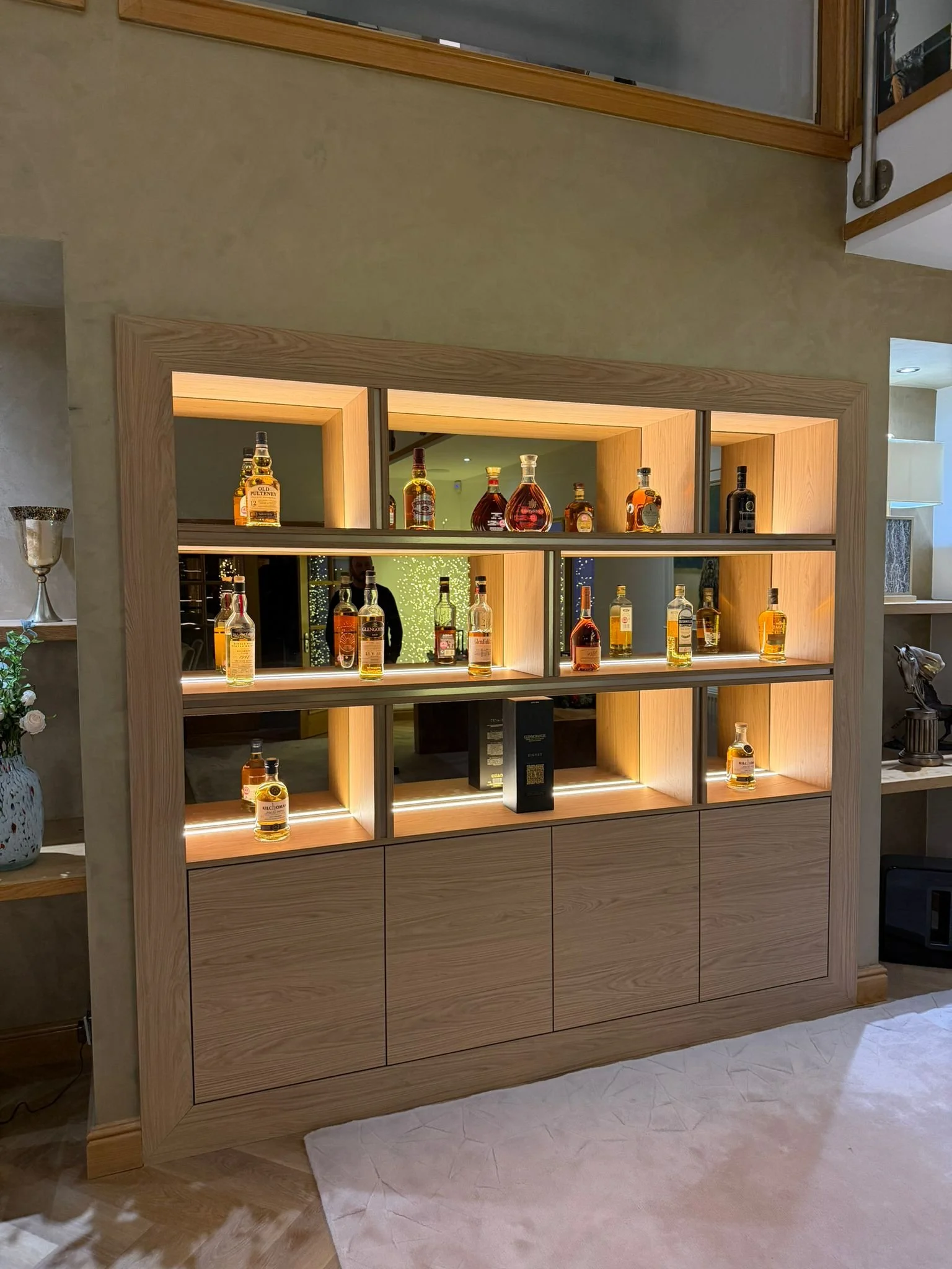 Drinks display with ambient LED lighting and storage cupboards. 