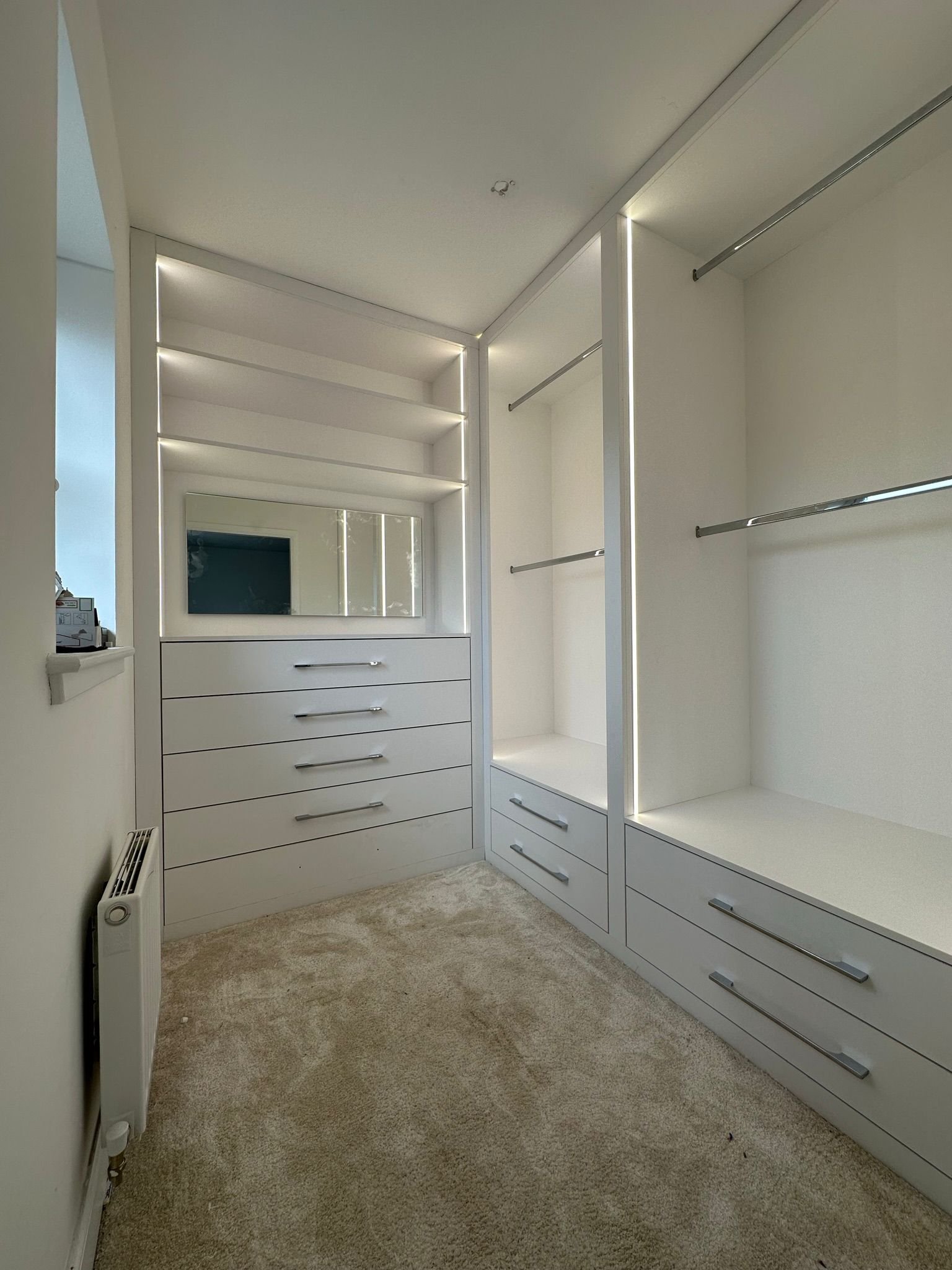 Walk-in wardrobe with hanging rails and drawers. 