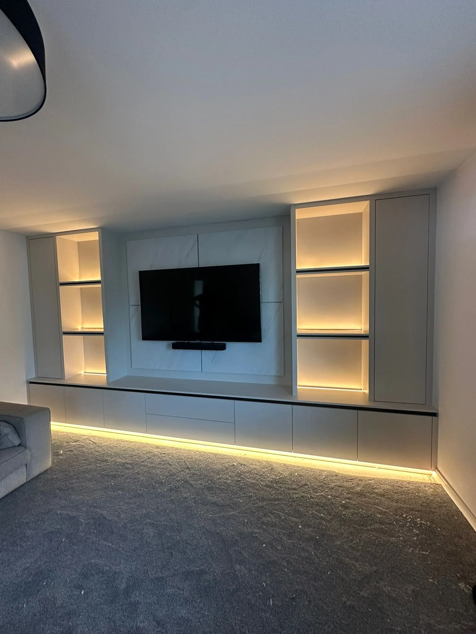 Custom built media wall with TV, shelving and feature LED lights.
