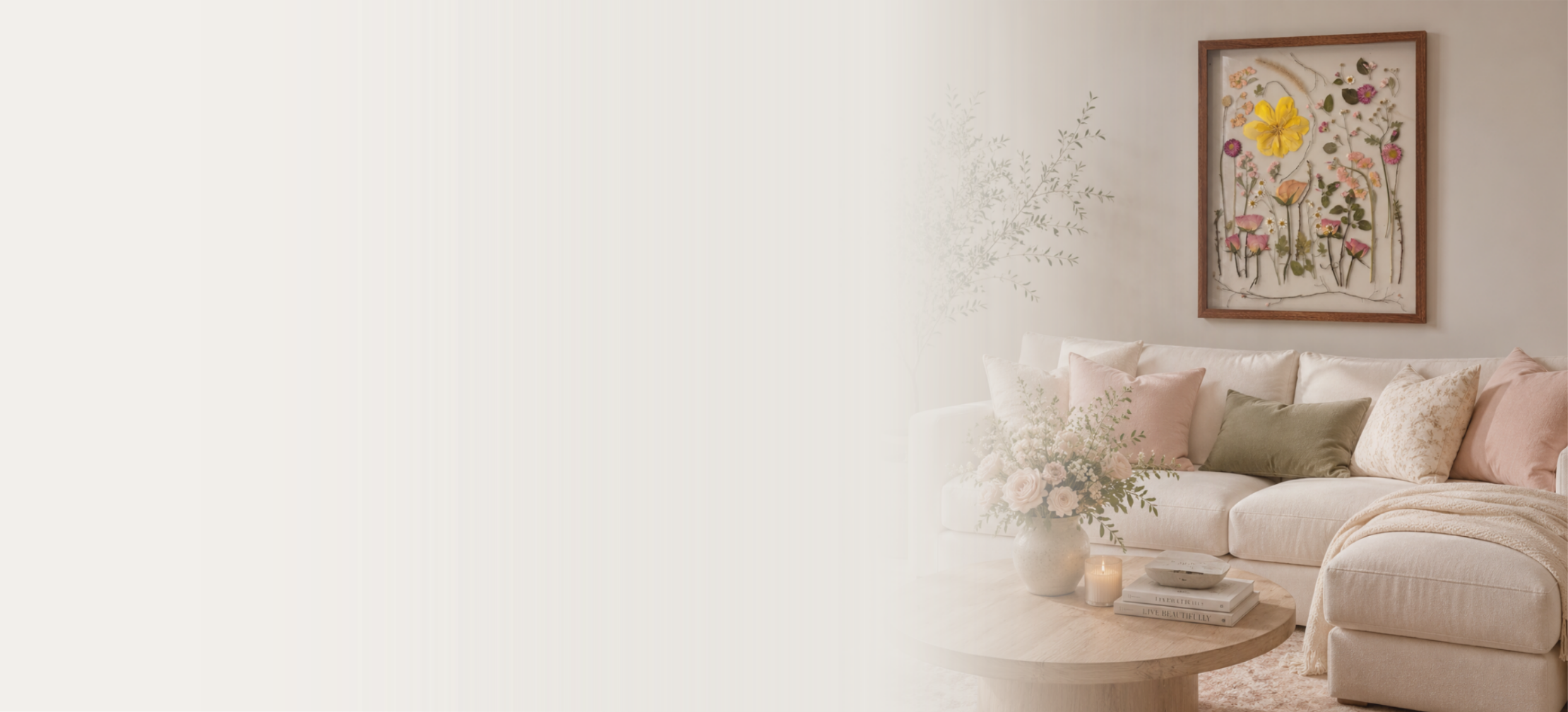 Living room with a beige sofa, pastel cushions, a wooden coffee table with books and flowers, and artwork of pressed flowers on the wall.