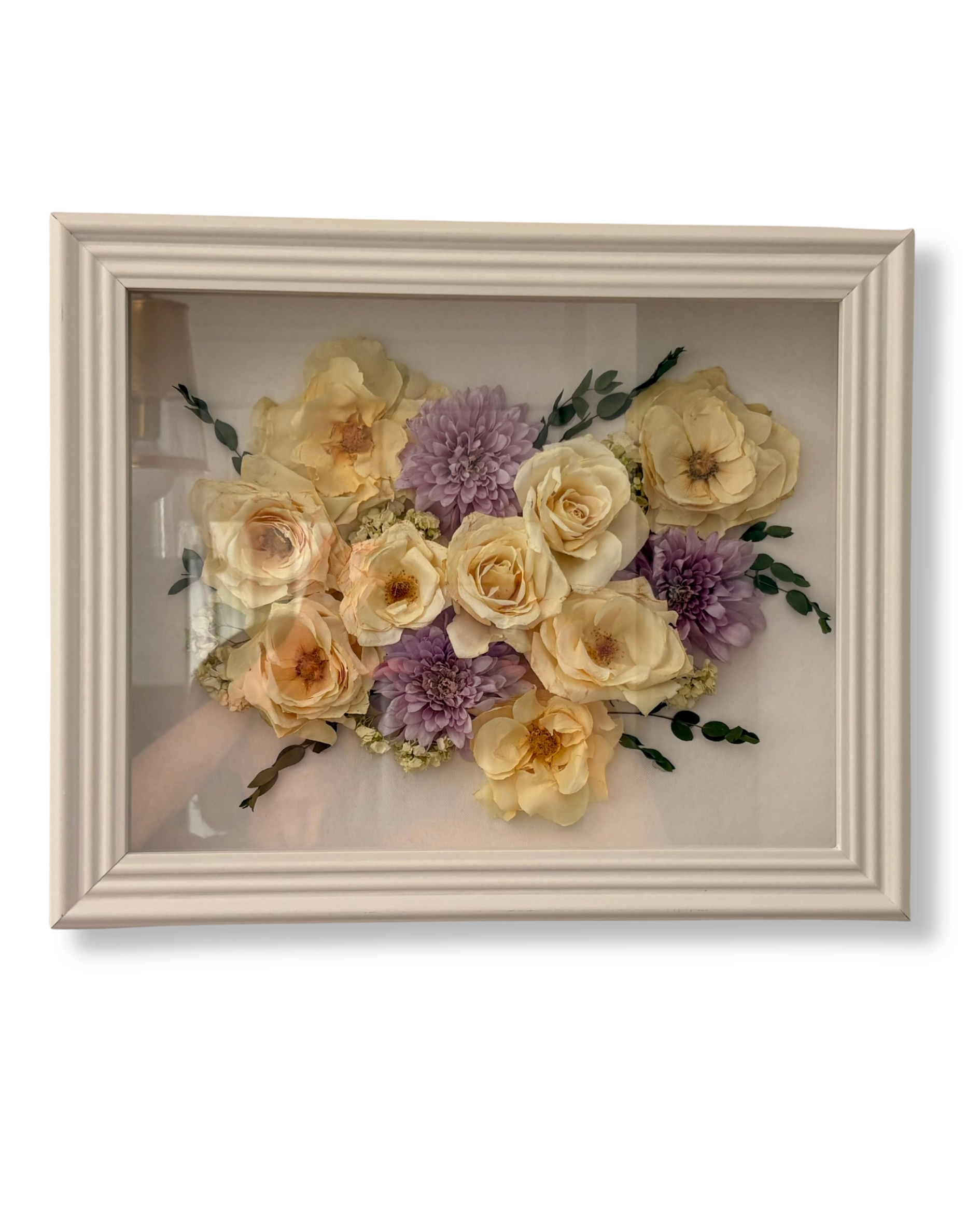 Framed floral arrangement with cream roses and purple dahlias