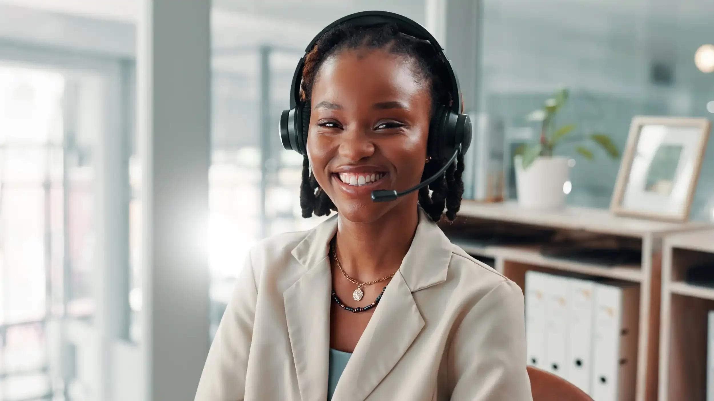 Healthcare support specialist or a patient support specialist smiling while wearing a headset in a professional office.