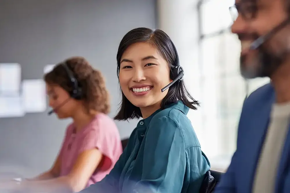 Patient support services team members wearing headsets in a professional office.