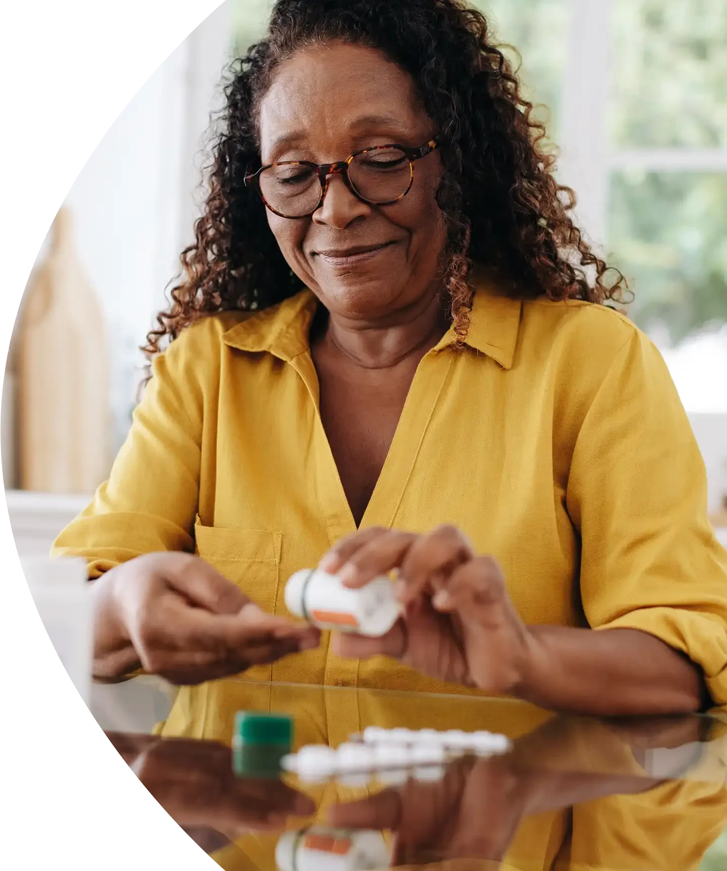 Woman reviewing her prescription medications at home as part of a patient assistance program.
