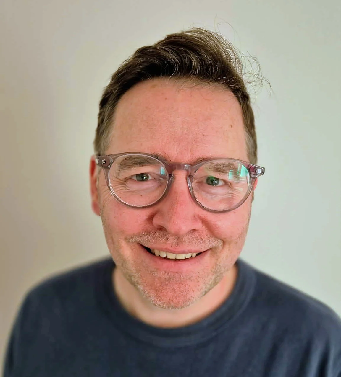 A woman sitting on a bench in a minimalist room, with sunlight casting shadows on the wall.