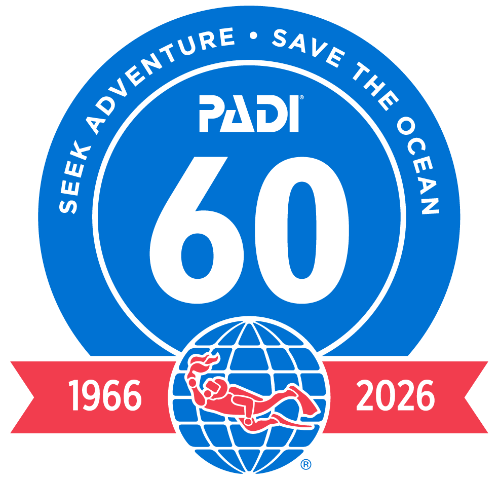 PADI 60th anniversary badge with a scuba diver illustration, the years 1966 and 2026, and the slogan 'Seek Adventure · Save the Ocean'.