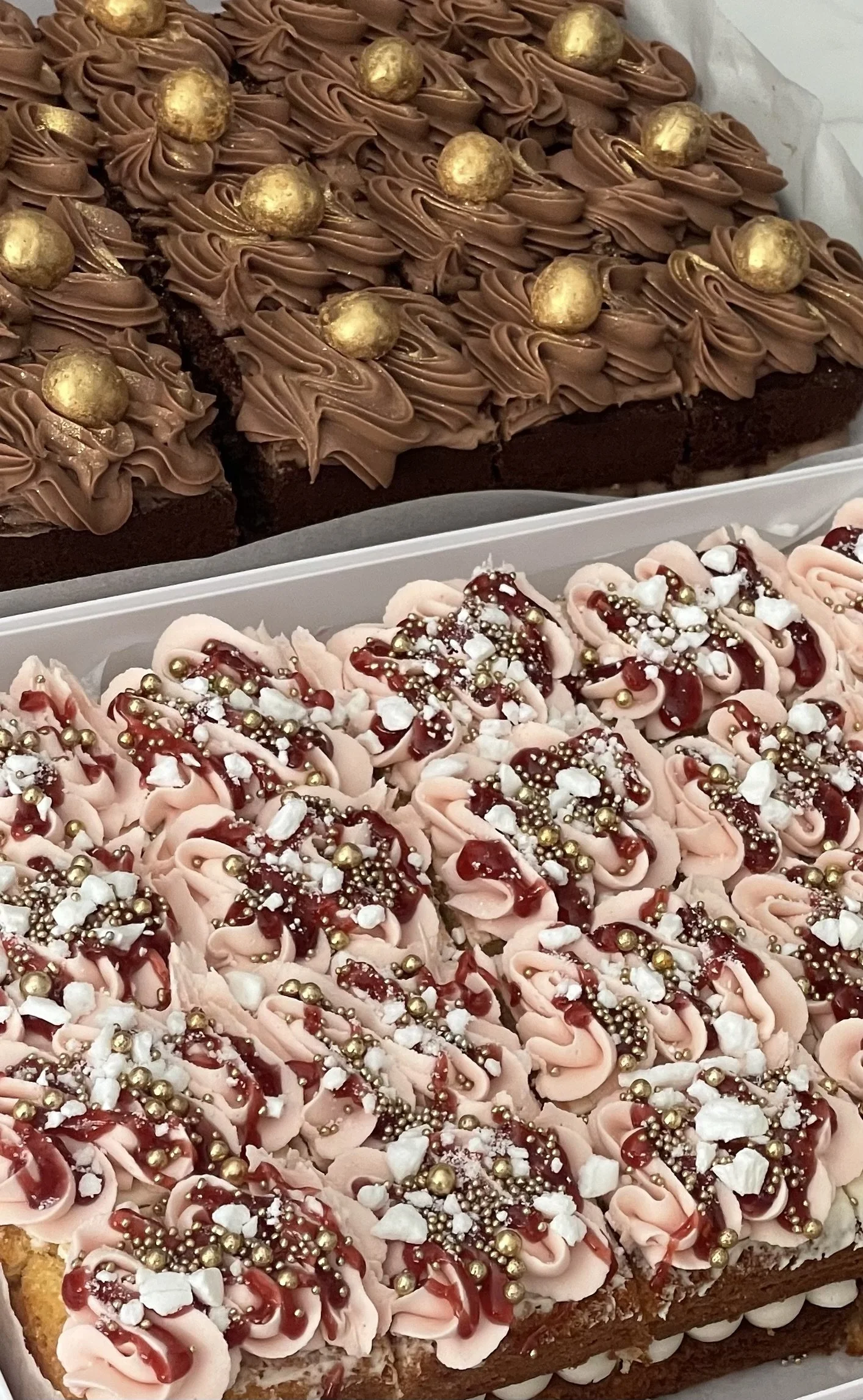 Decorative cakes with chocolate frosting and gold balls; one cake has pink frosting with sprinkles and edible pearls.