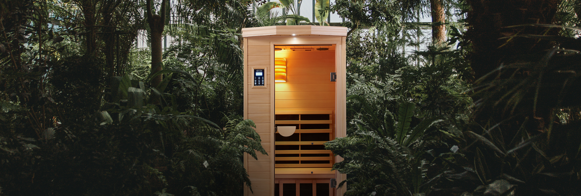 Small wooden sauna in a lush, tropical forest.