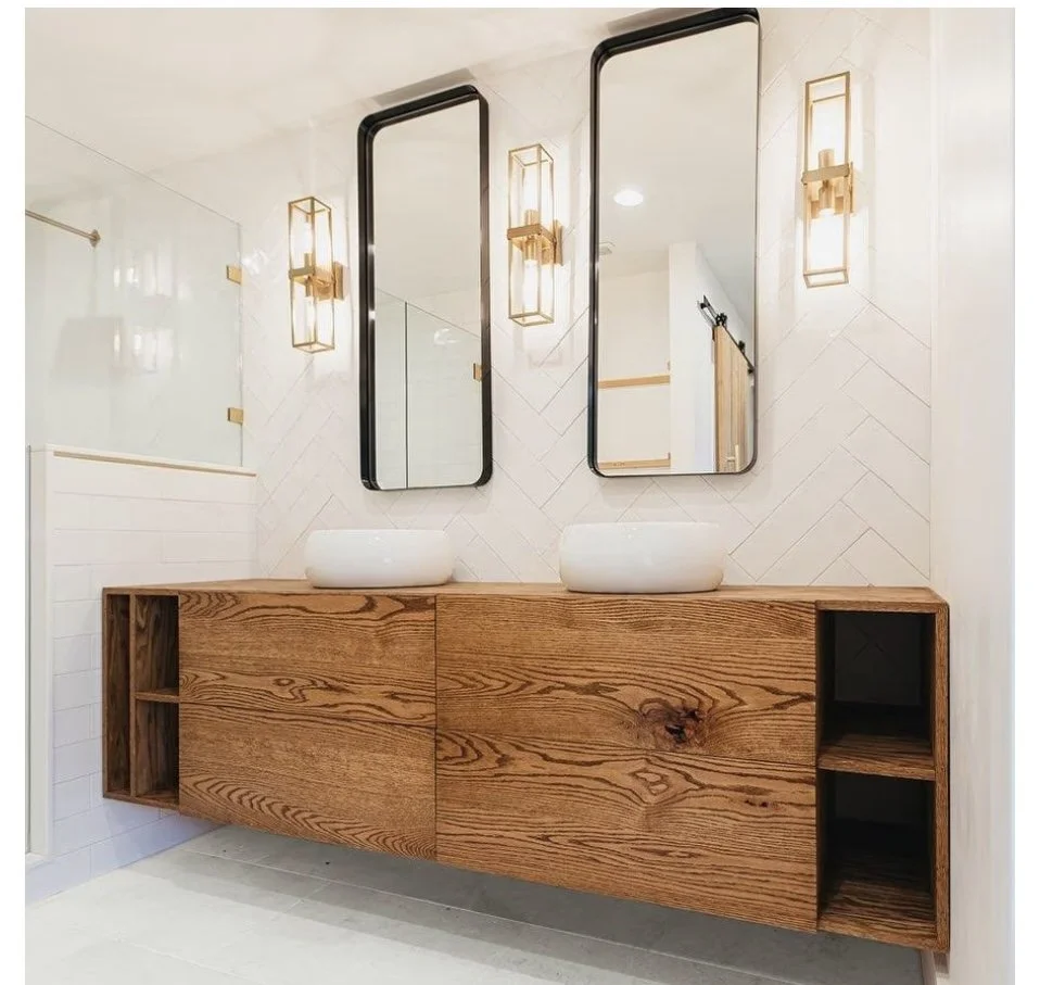 Modern bathroom with two oval vessel sinks on a wooden floating vanity, two tall rectangular mirrors, and matching wall-mounted light fixtures.