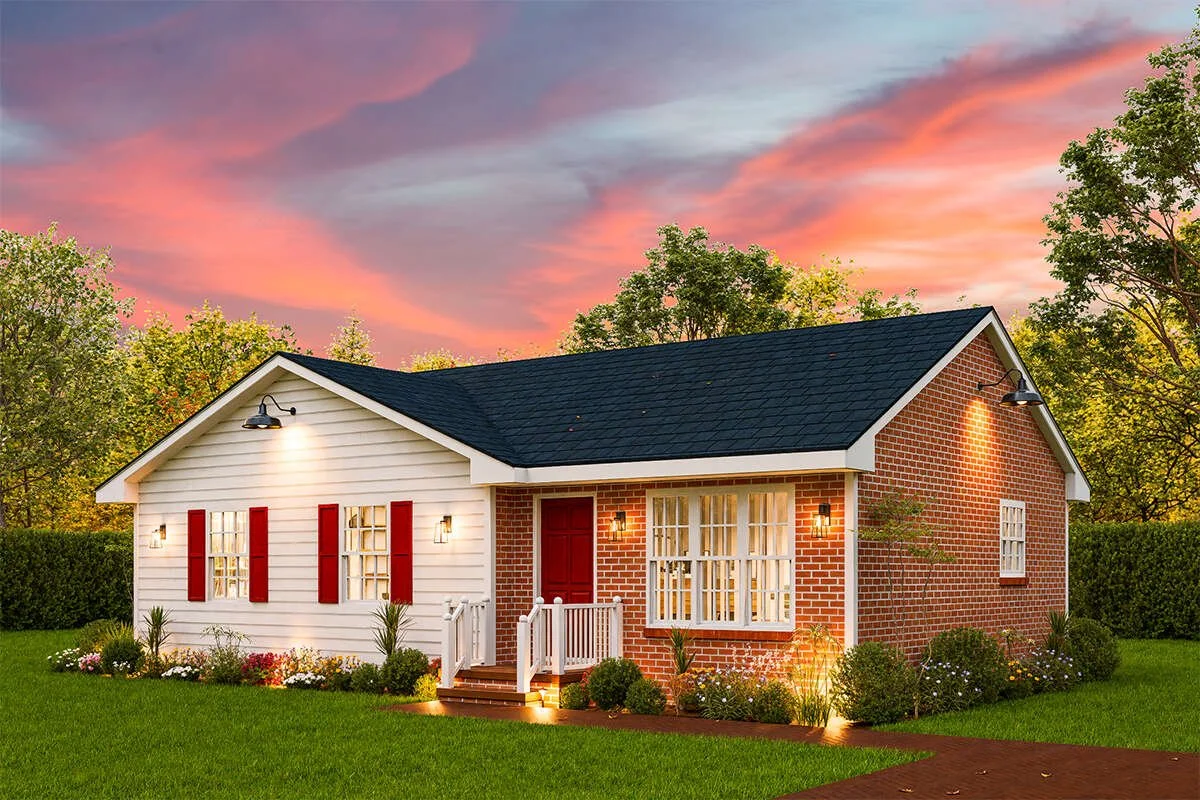 A cozy house during sunset with a brick and white exterior, black roof, red front door, and warm lighting, surrounded by a well-maintained garden and green lawn.