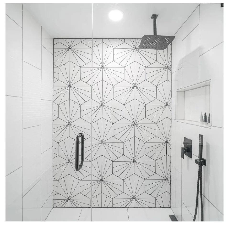 Modern shower with geometric patterned accent wall, rainfall showerhead, and hand-held shower fixture.