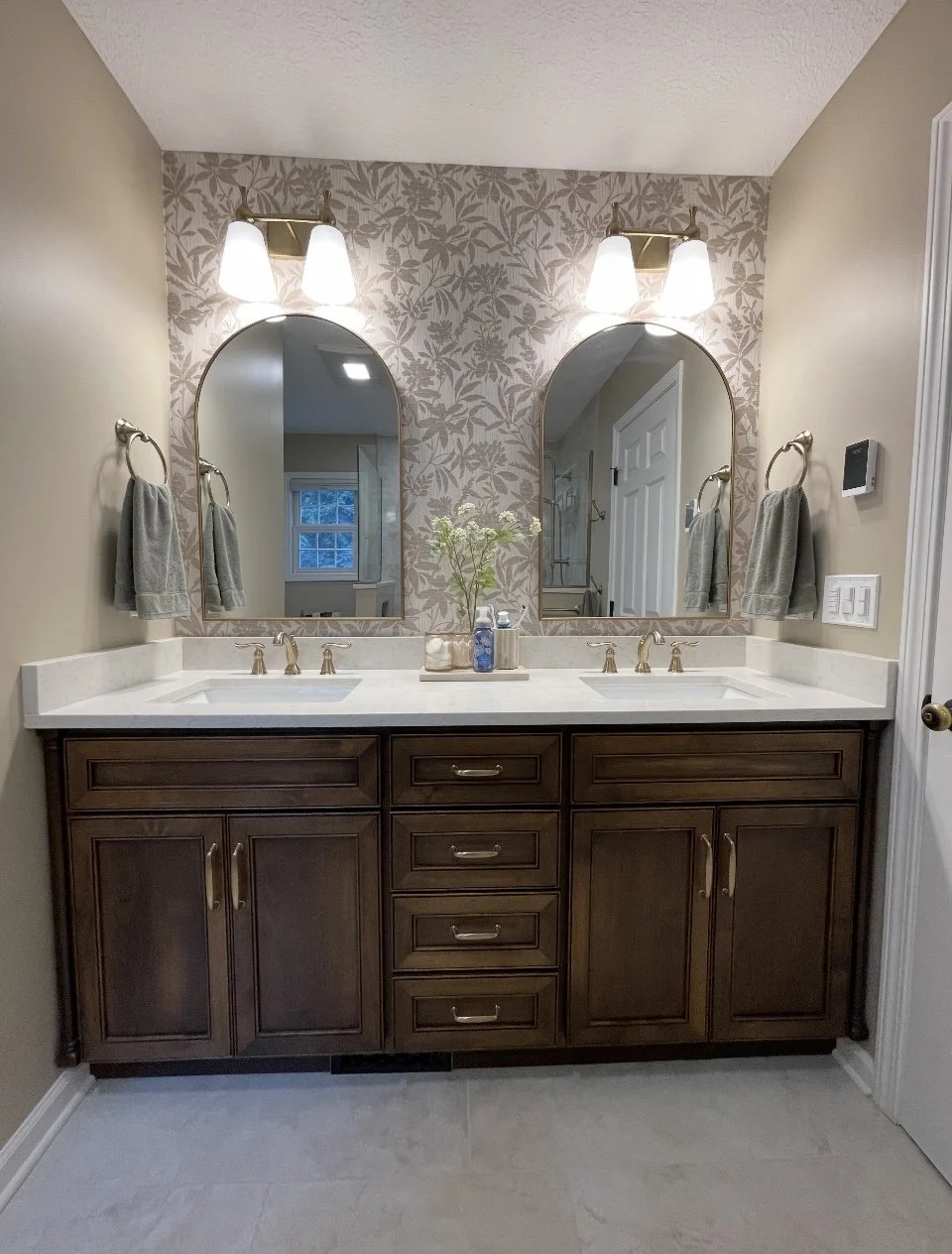 Double bathroom vanity with two mirrors, two light fixtures, and a matching set of towels on each side.