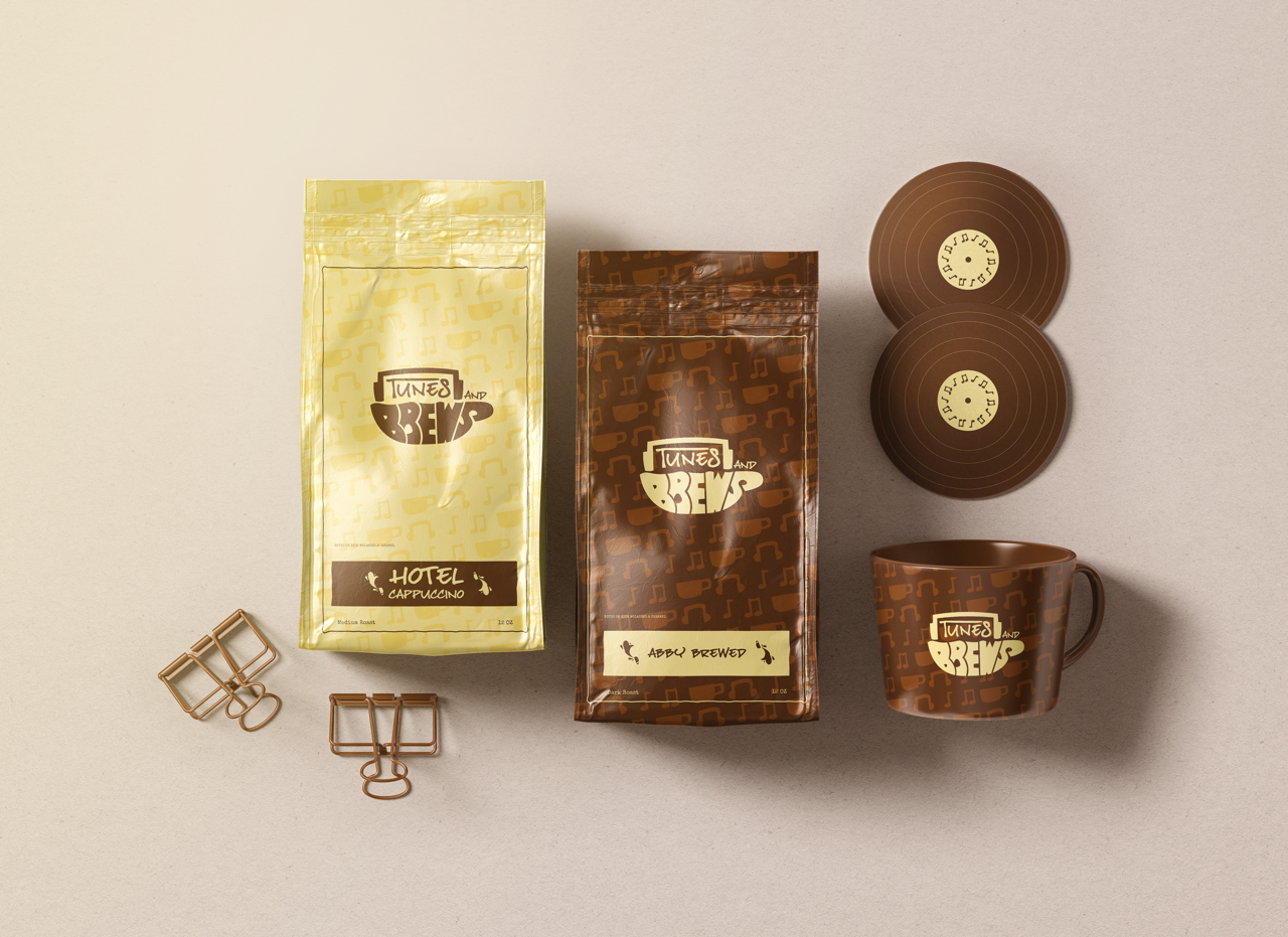 Coffee packets labeled 'Tune's and Brews' with a brown and yellow motif, two brown coasters with concentric circles and a small logo, a brown mug with the same logo and pattern, and two decorative paper clips on a light background.