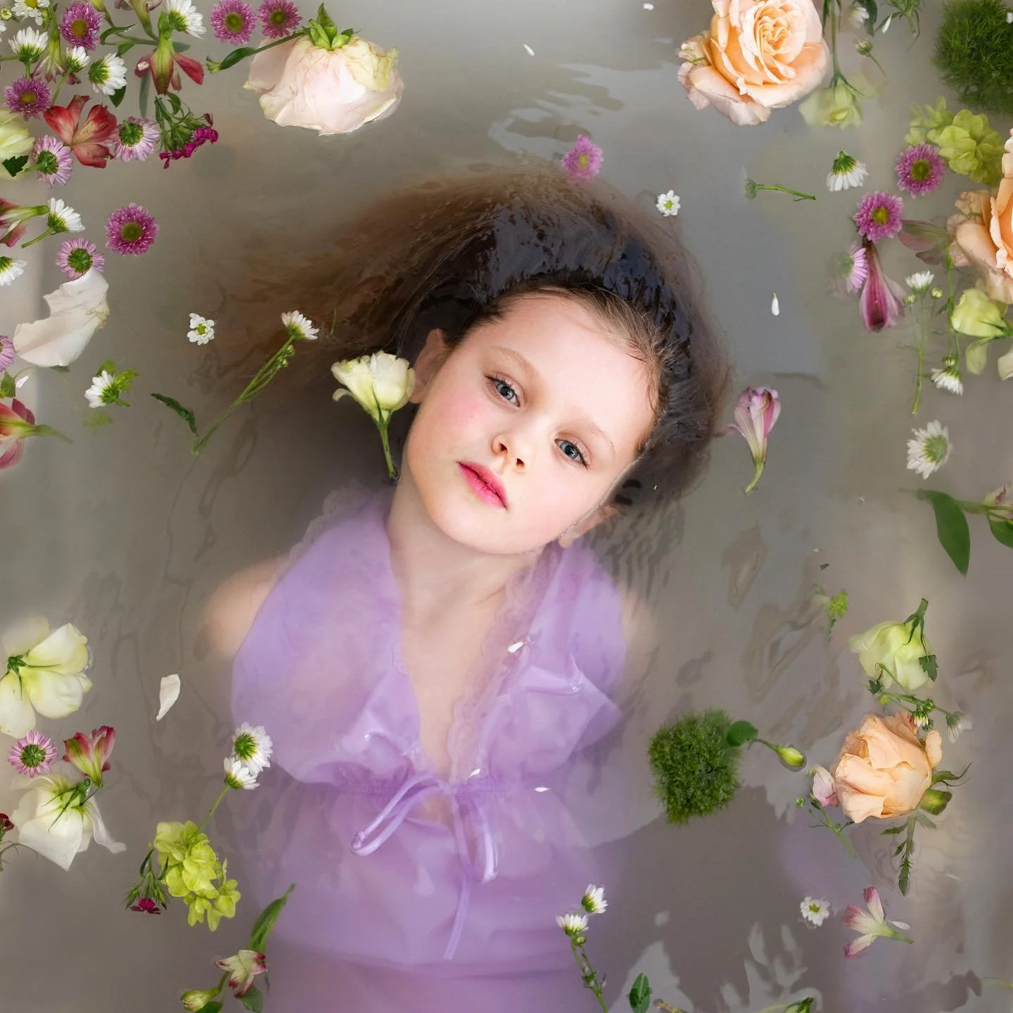 Cora Dorothy, age 7. 

After a maternity bathtub shoot the girls wanted to take photos too so they grabbed some nightgowns and asked me to photograph them. It reminded me of Gustav Klimts &ldquo;Water Serpent&rdquo; paintings ❤️
