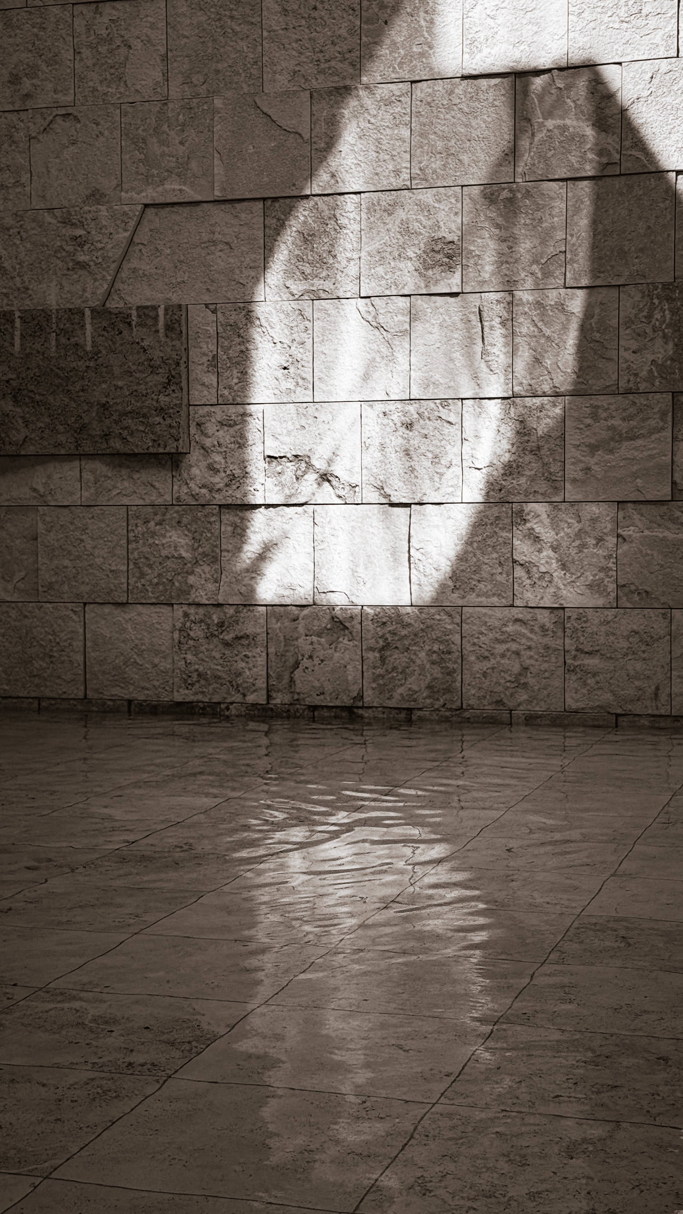 Light casting shadows on a stone wall, evoking stillness and presence at a Human Design gathering