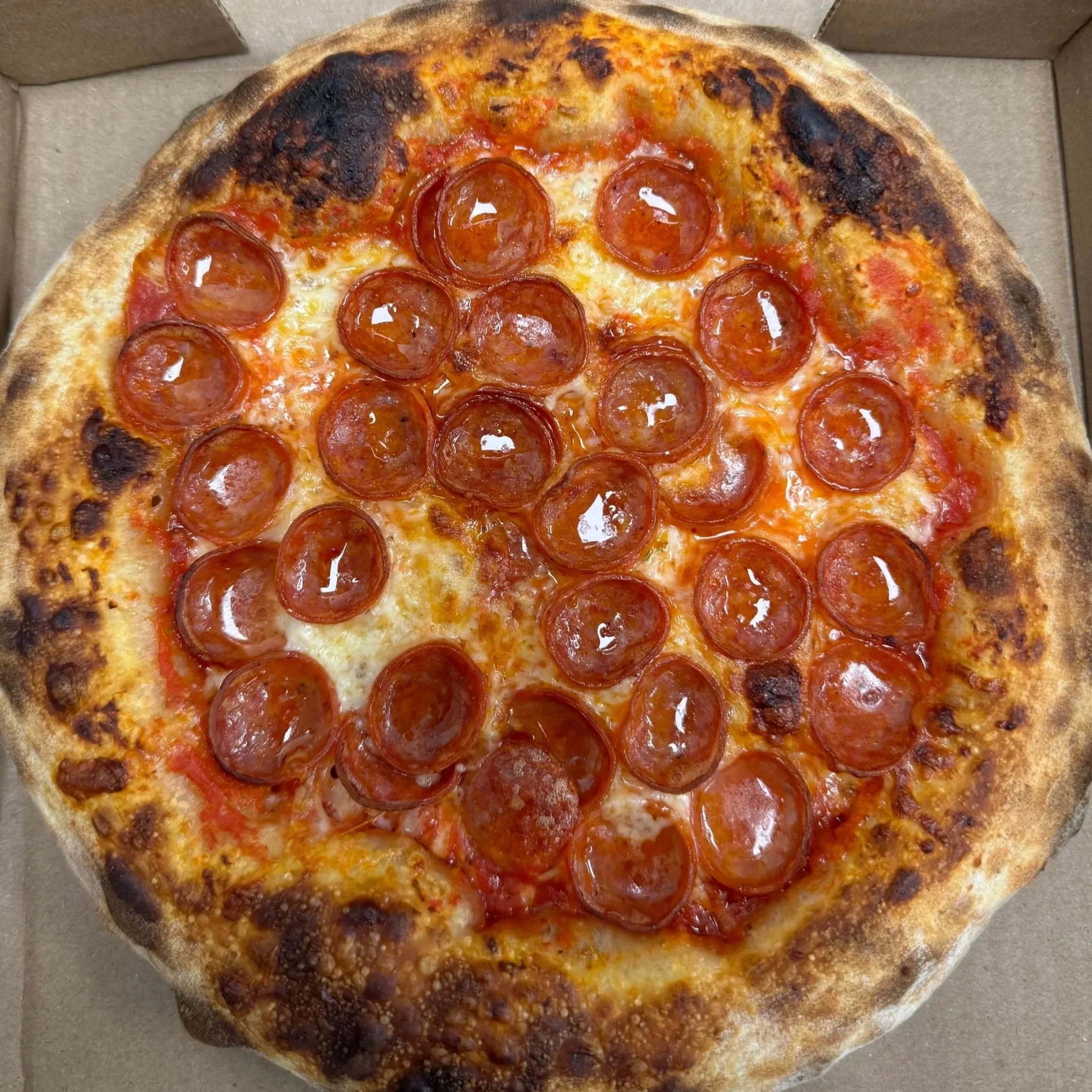 A pepperoni pizza in a cardboard pizza box