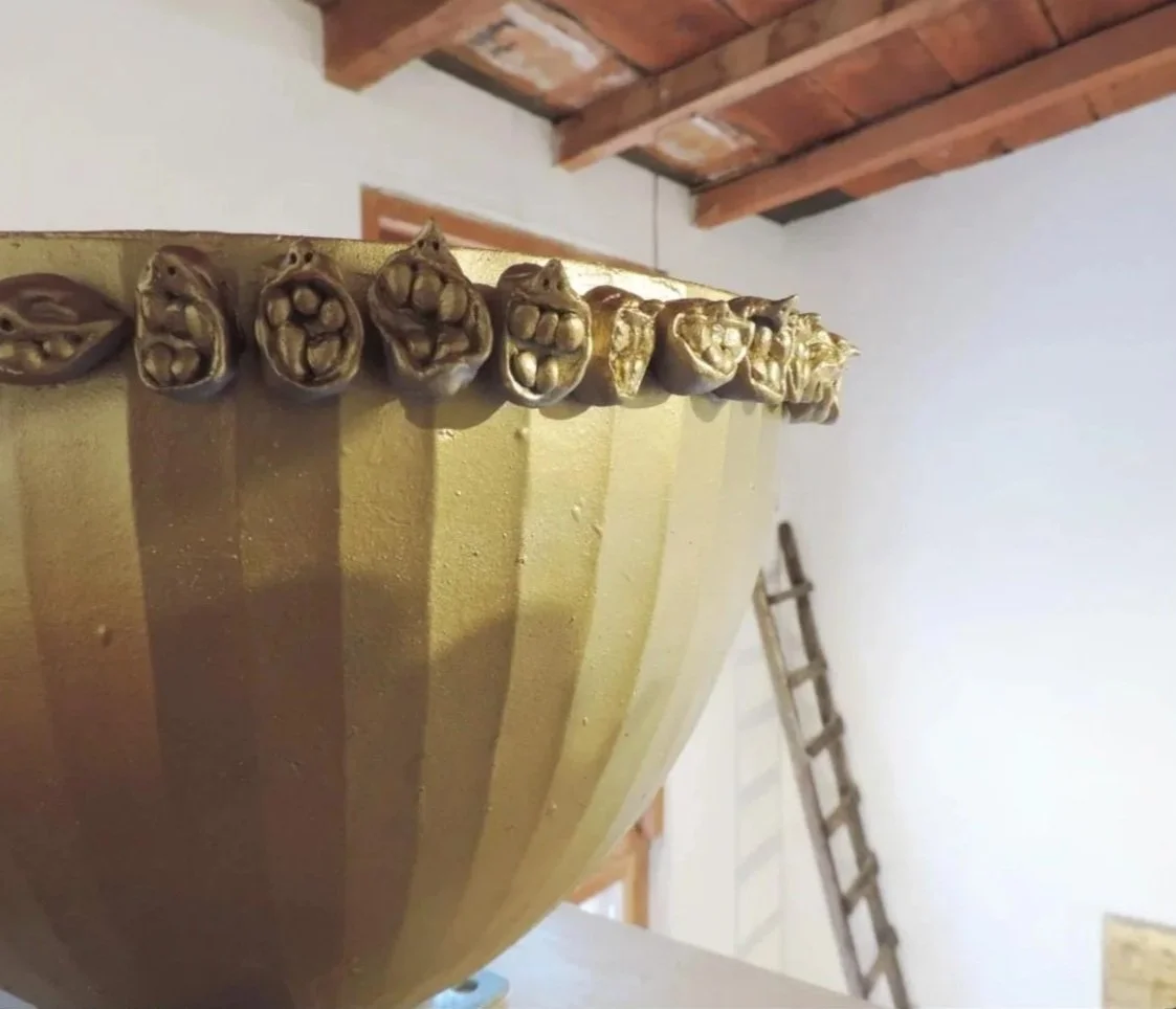 Vista de una embarcación de madera con detalles decorativos en la parte superior y un fondo de techo de madera y pared blanca.