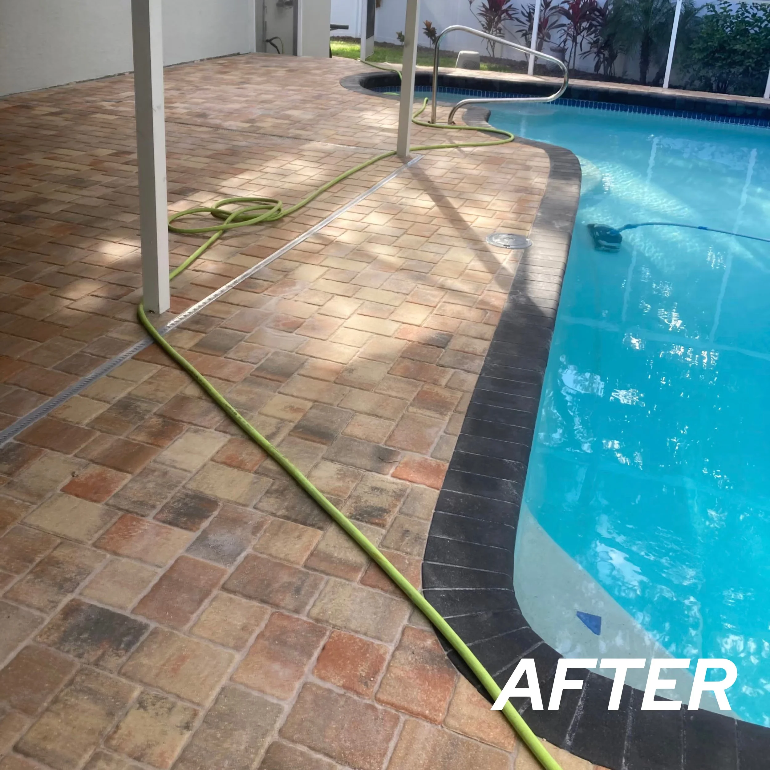 Cleaned and repaired pool deck with new brick pavers and black border around the pool.