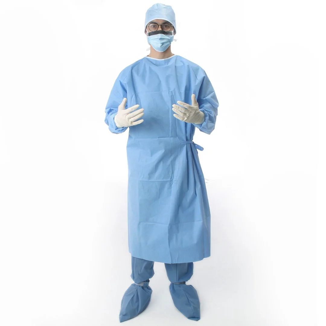 Tıbbi ortamda giyen doktor veya sağlık çalışanı, mavi tulum, bone, maske, gözlük ve eldiven takmış.