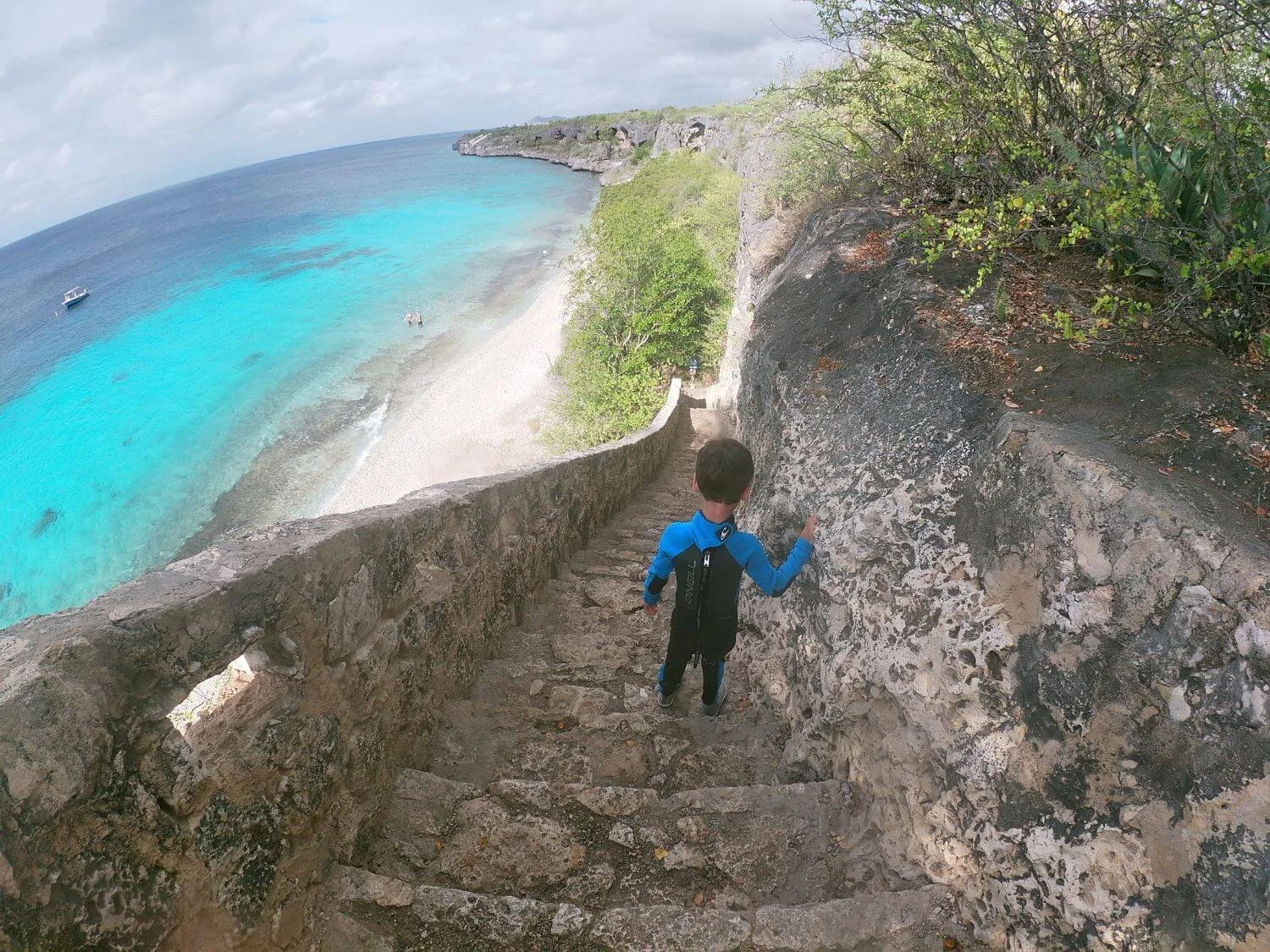 Boy walking down 1000 steps in Bonaire to snorkel.