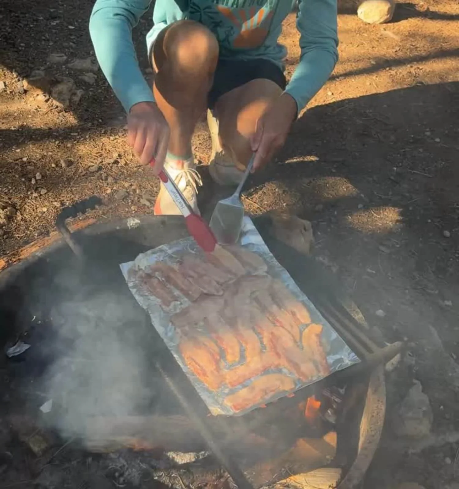 Bacon being cooked over the camp fire at a campsite in Mather Campground in Grand Canyon National Park, Arizona, USA