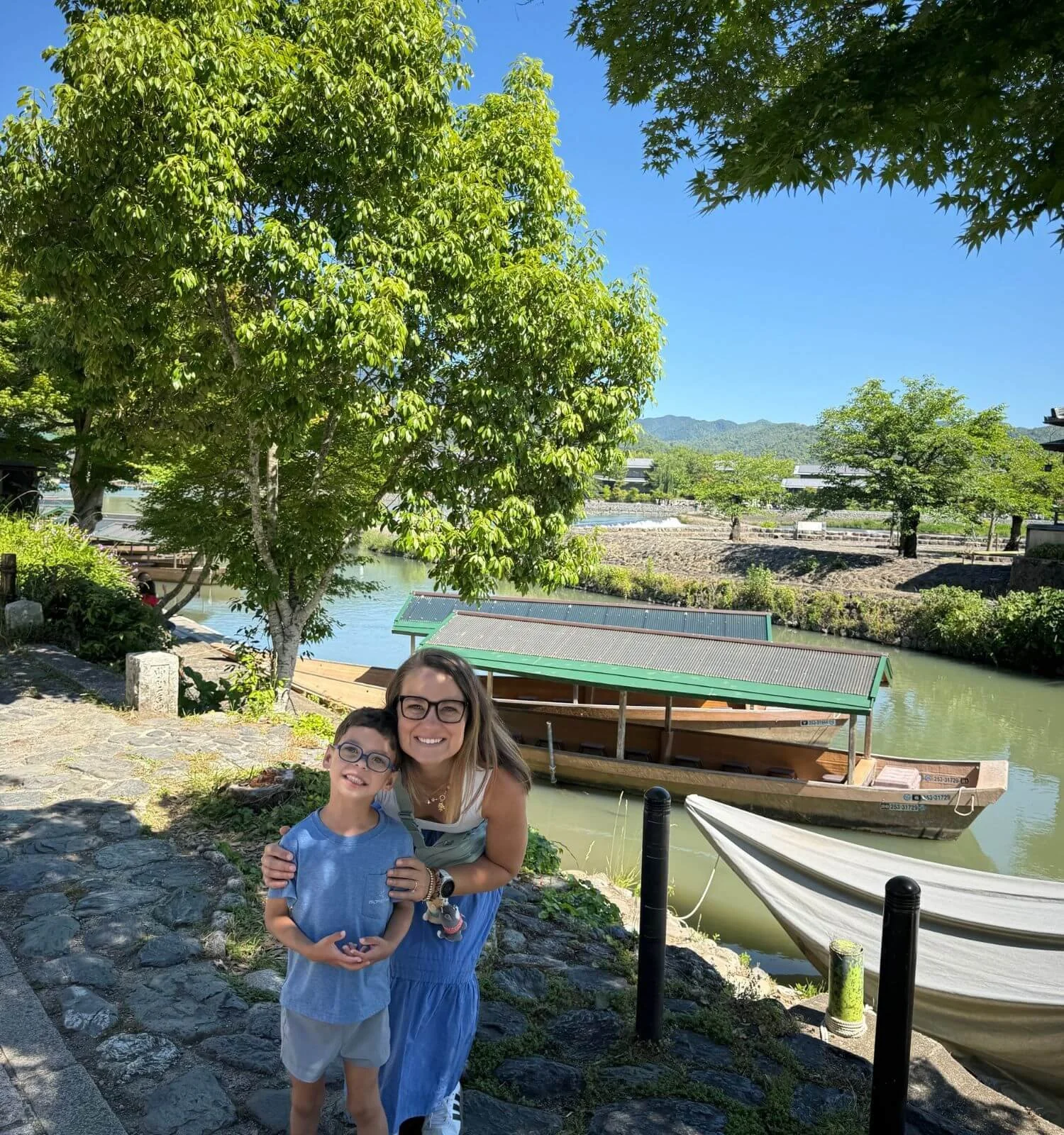Beside the river in Arashiyama, with a traditional Japanese boat behind us