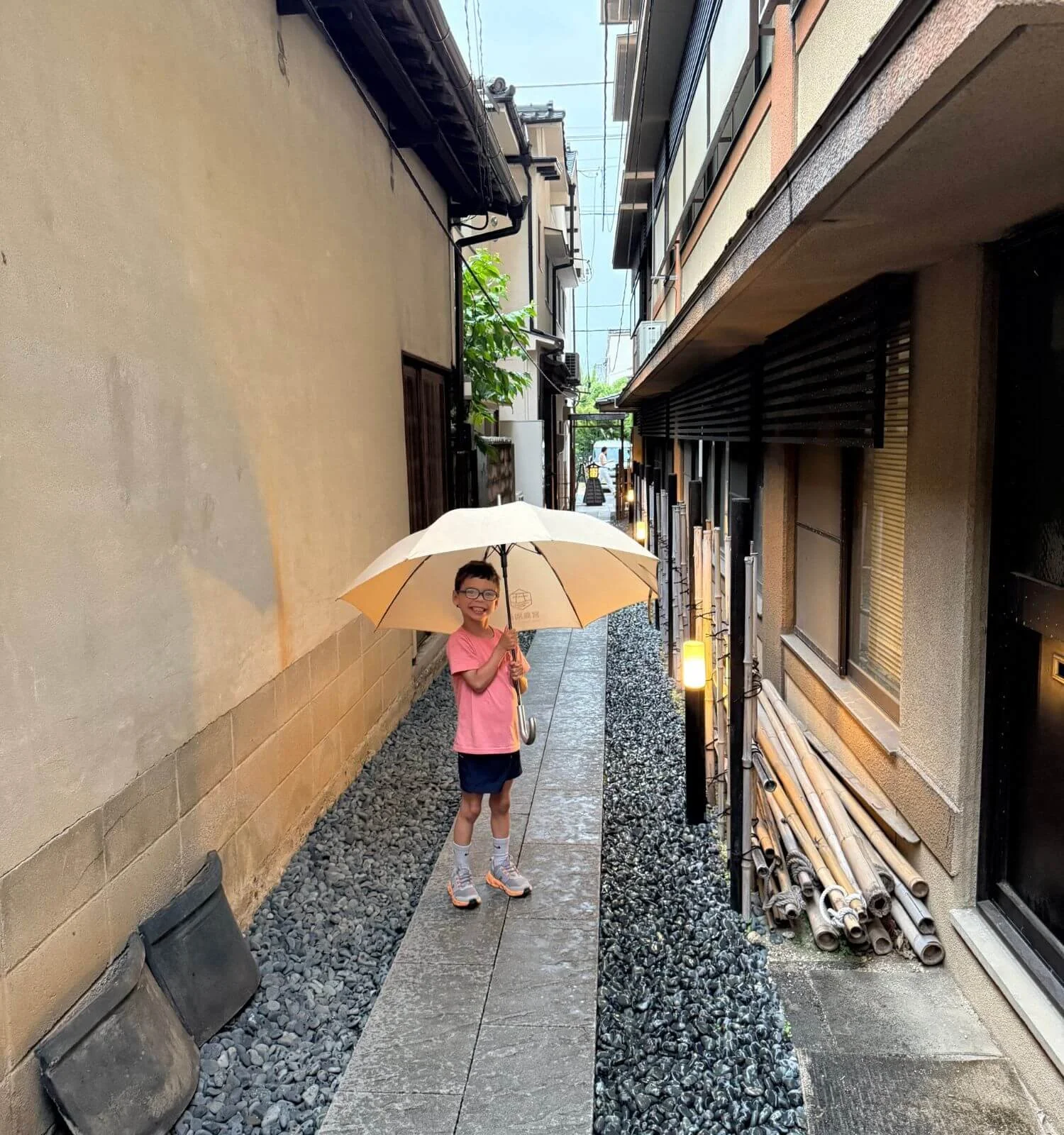 Boy with umbrella on a quiet Miyajima street after crowds left island for the day.