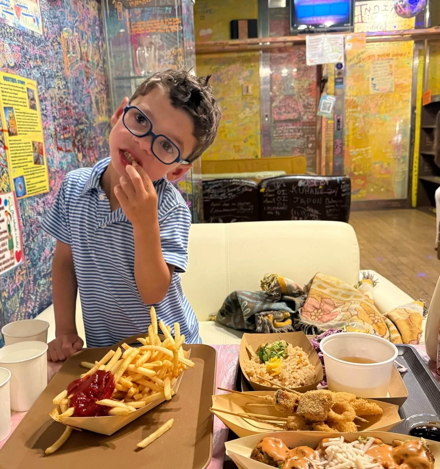 Boy eating gluten free takoyaki at a shop in Osaka, Japan.
