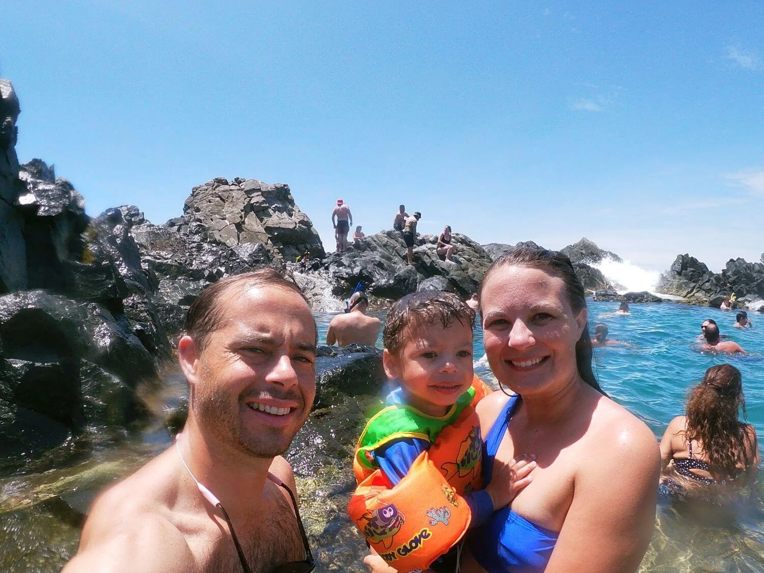 Family of three at Conchi Natural Pool in Arikok National Park, Aruba.