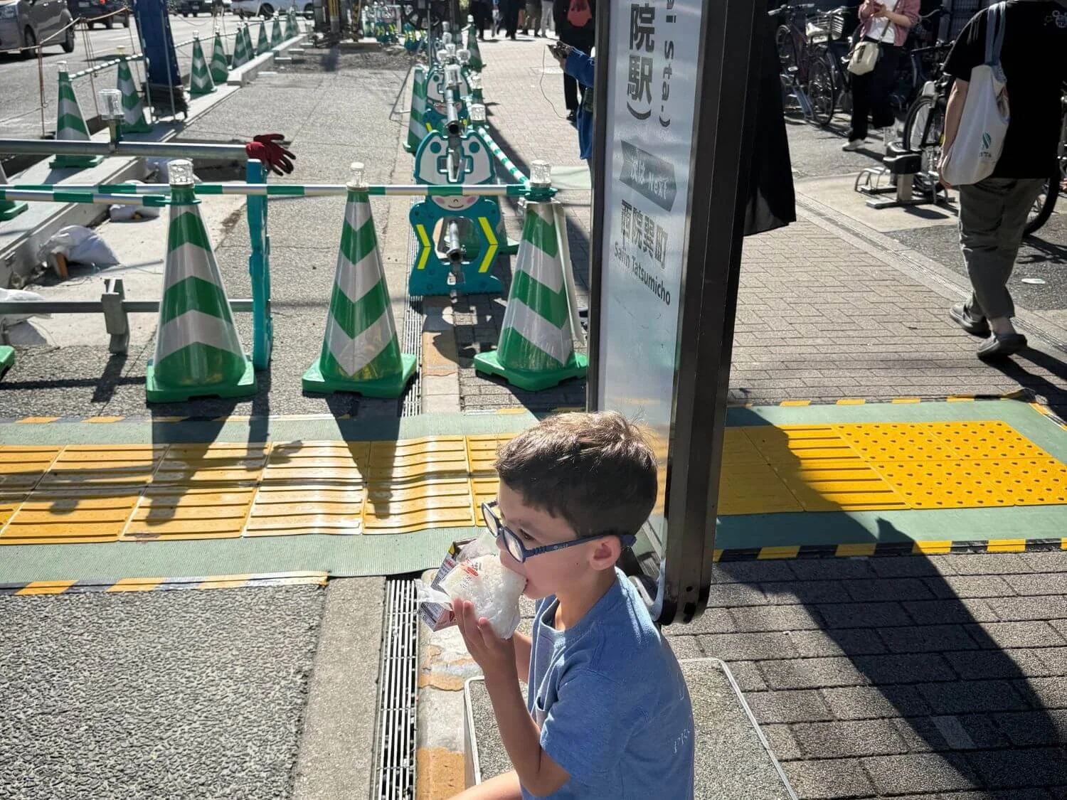 Young boy at a city bus stop in Kyoto, Japan
