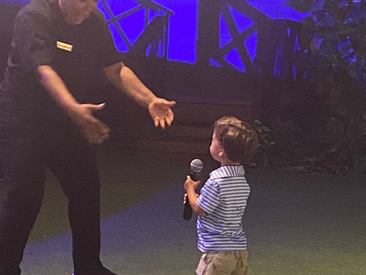 Boy singing with a microphone at a show at Hyatt Ziva Cap Cana in the Dominican Republic.