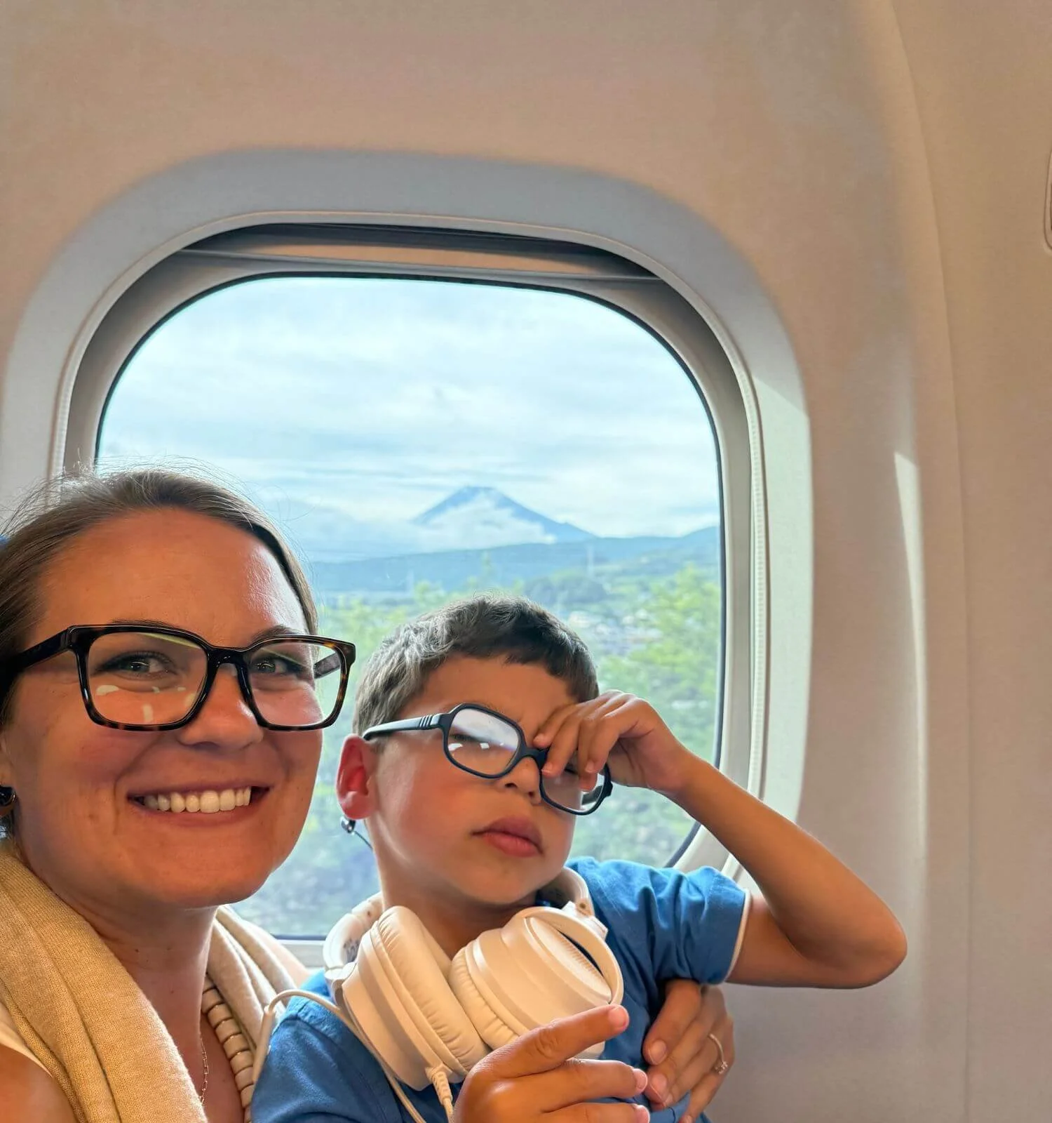 Mother and son riding the Shinkansen with Mount Fuji visible through the train window in Japan