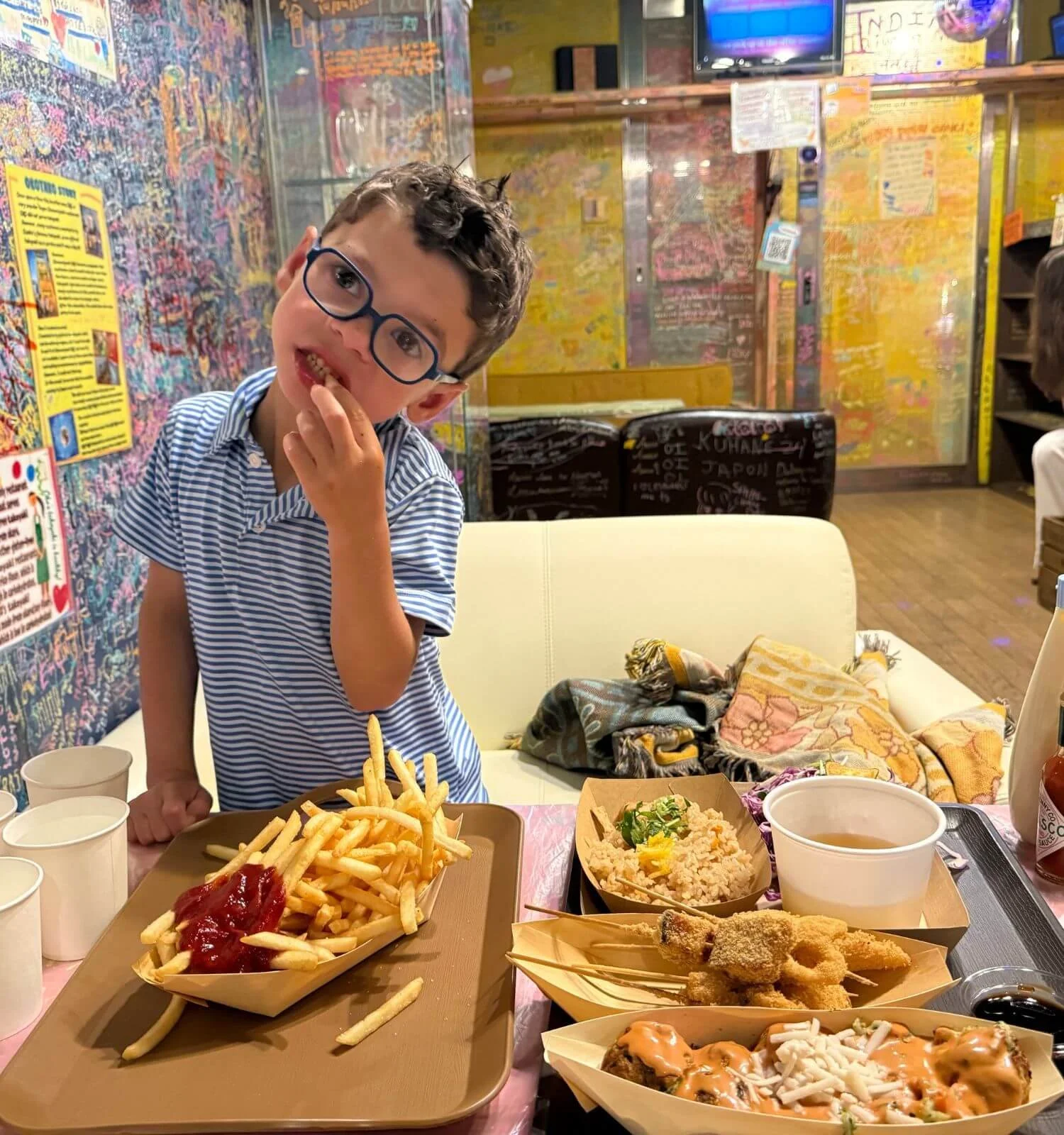 Boy eating gluten-free takoyaki in Osaka, Japan