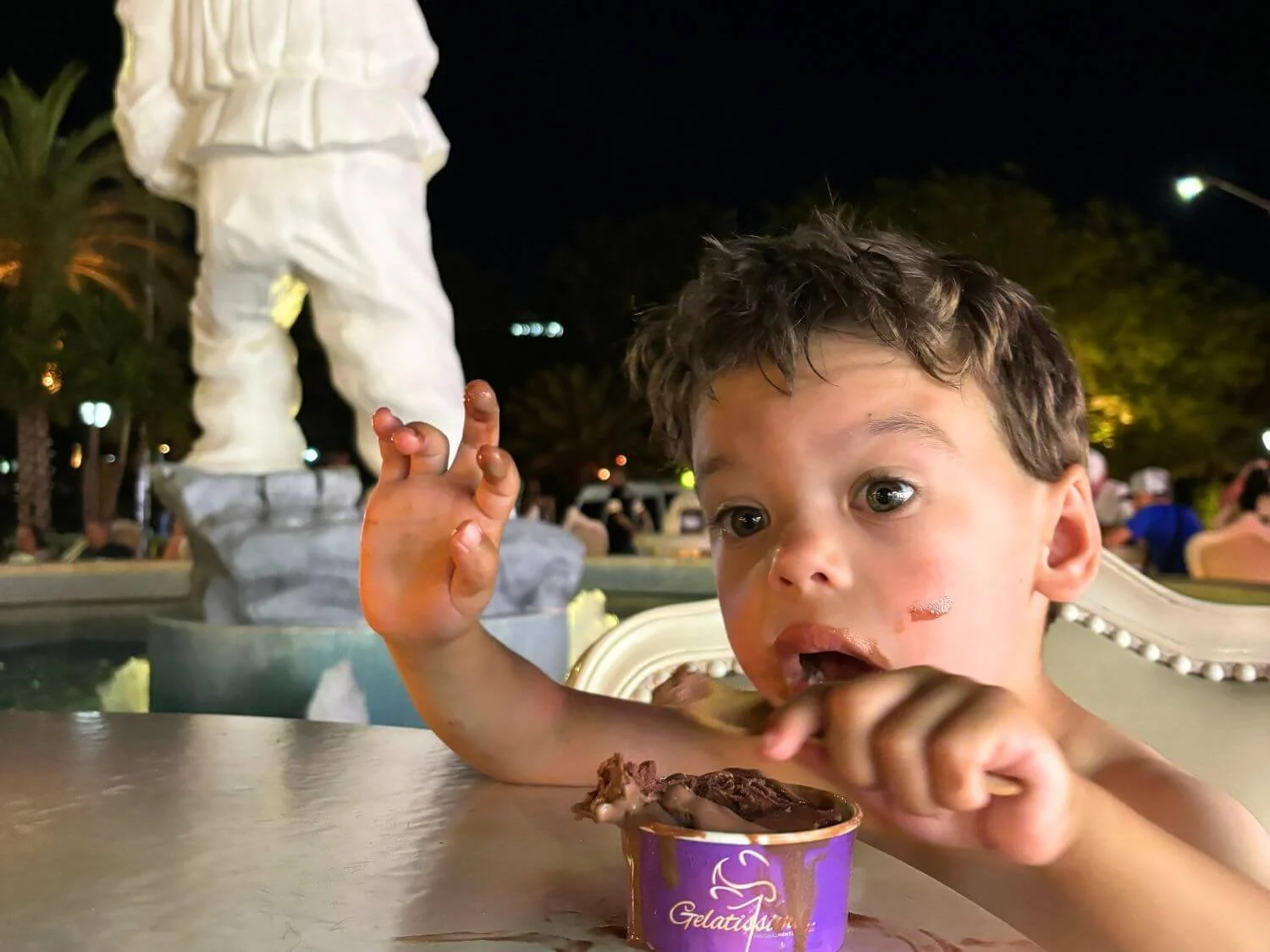 Toddler eating ice cream on the Palm Beach strip in Aruba.