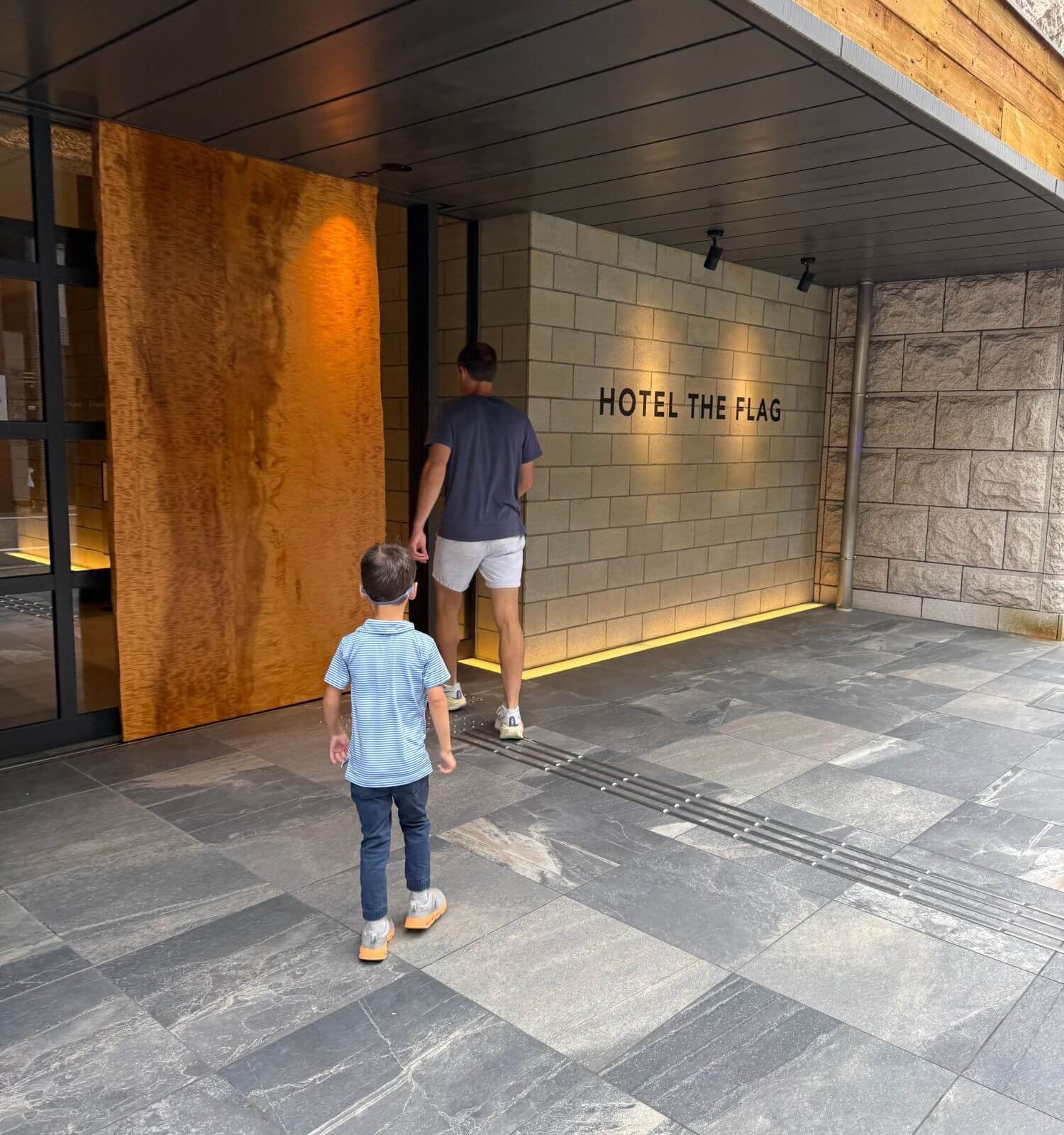 Image of father and son walking into Hotel The Flag Shinsaibashi in Osaka, Japan.