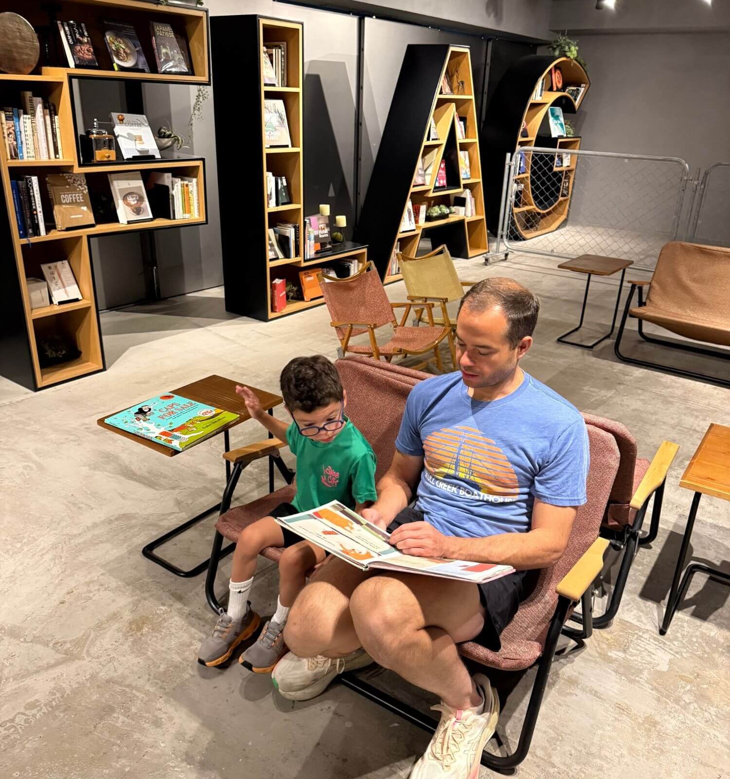 Dad reading to son in a hotel lobby in Osaka, Japan.