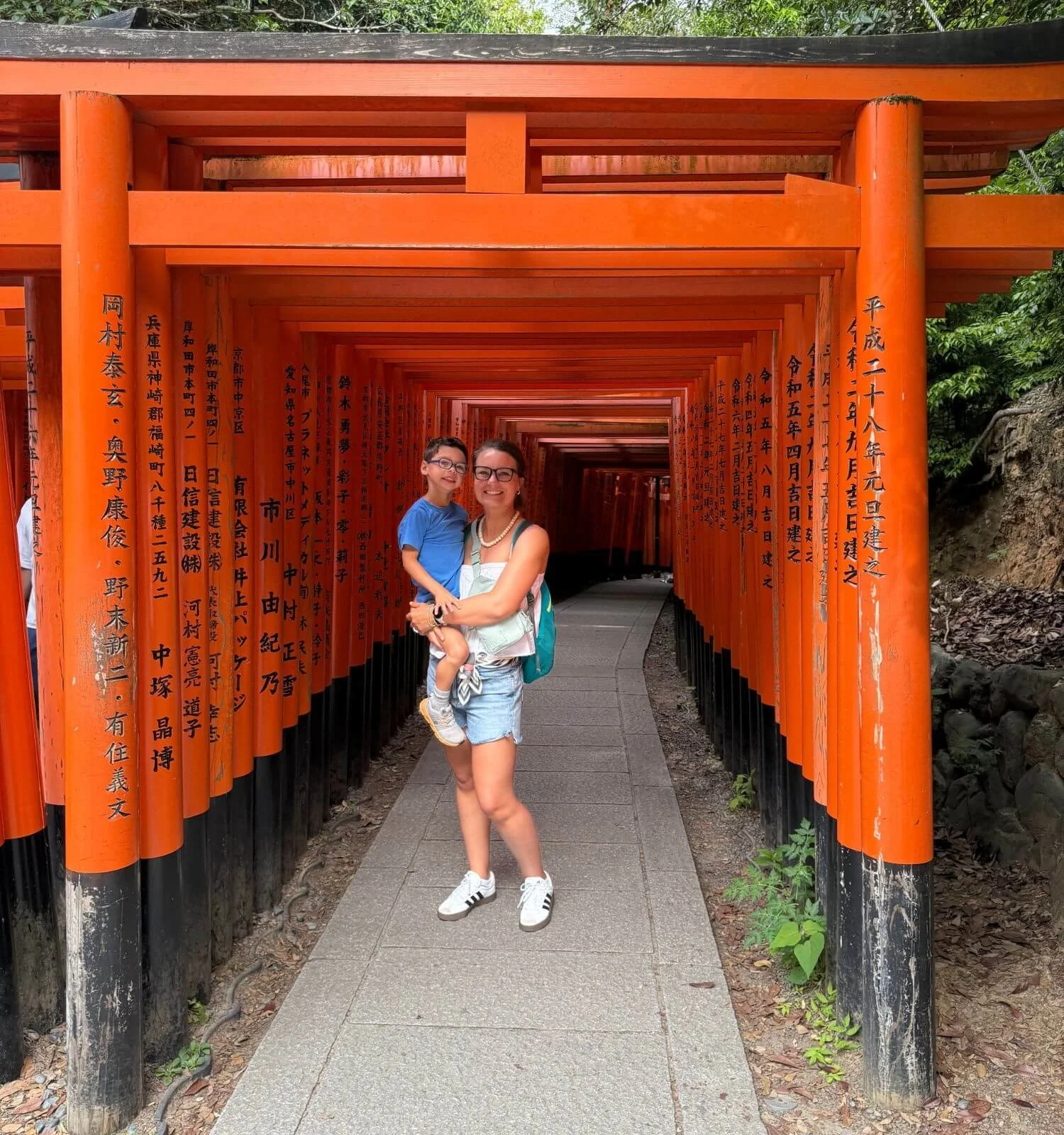 Mom holding her son at Fushimi Inari Taisha in Kyoto, Japan.