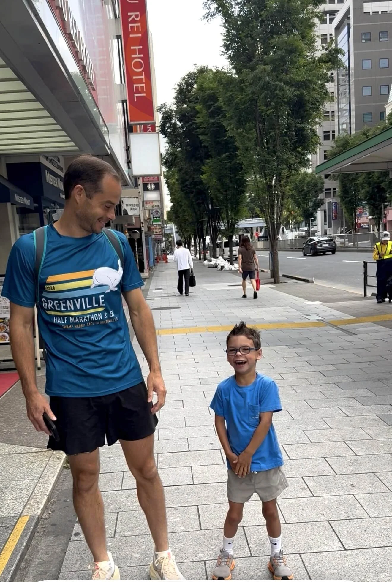 Father and son standing outside Shibuya Tokyu REI Hotel in Tokyo, Japan