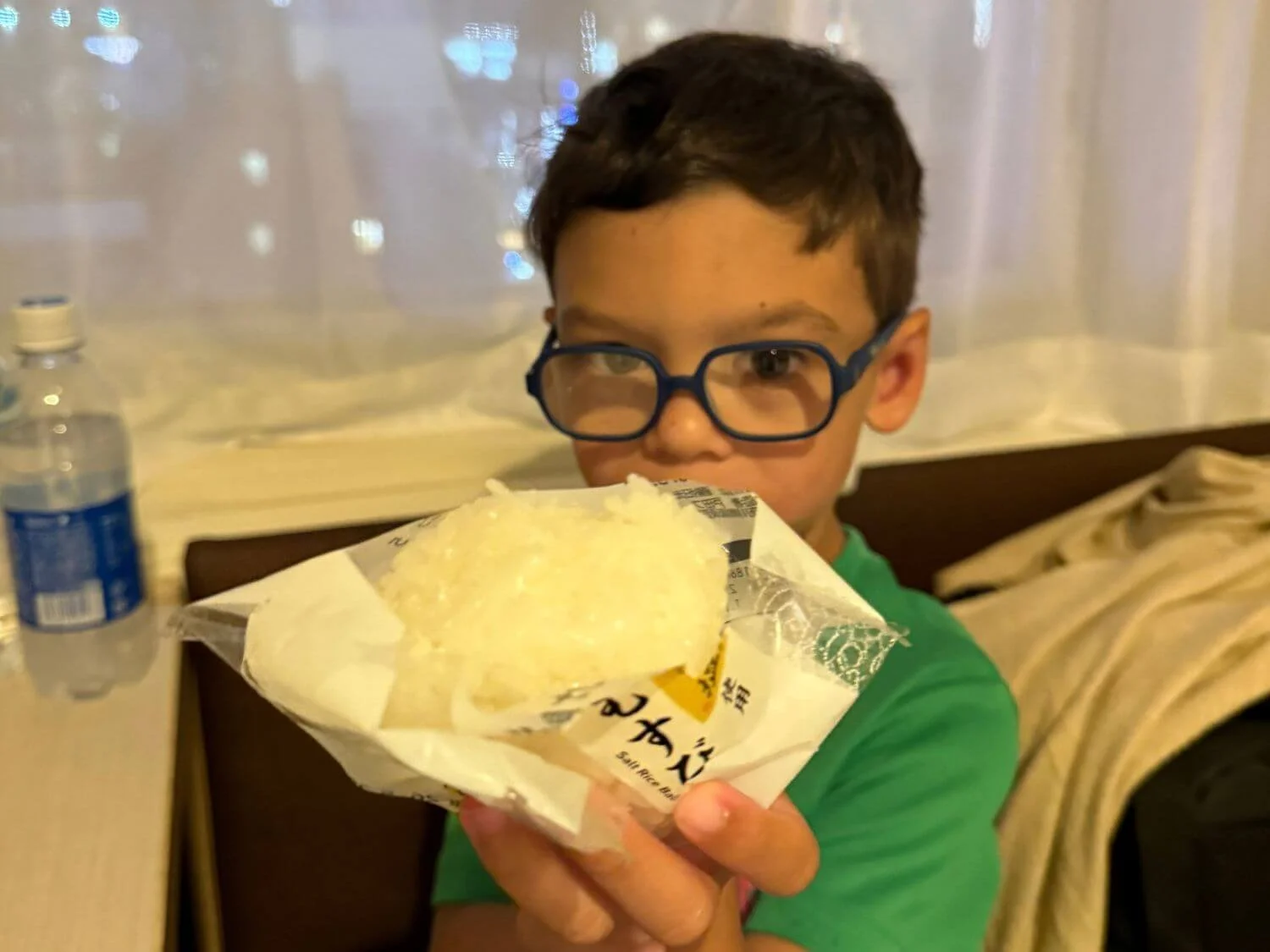 Boy holding rice ball from convenience store in Tokyo, Japan