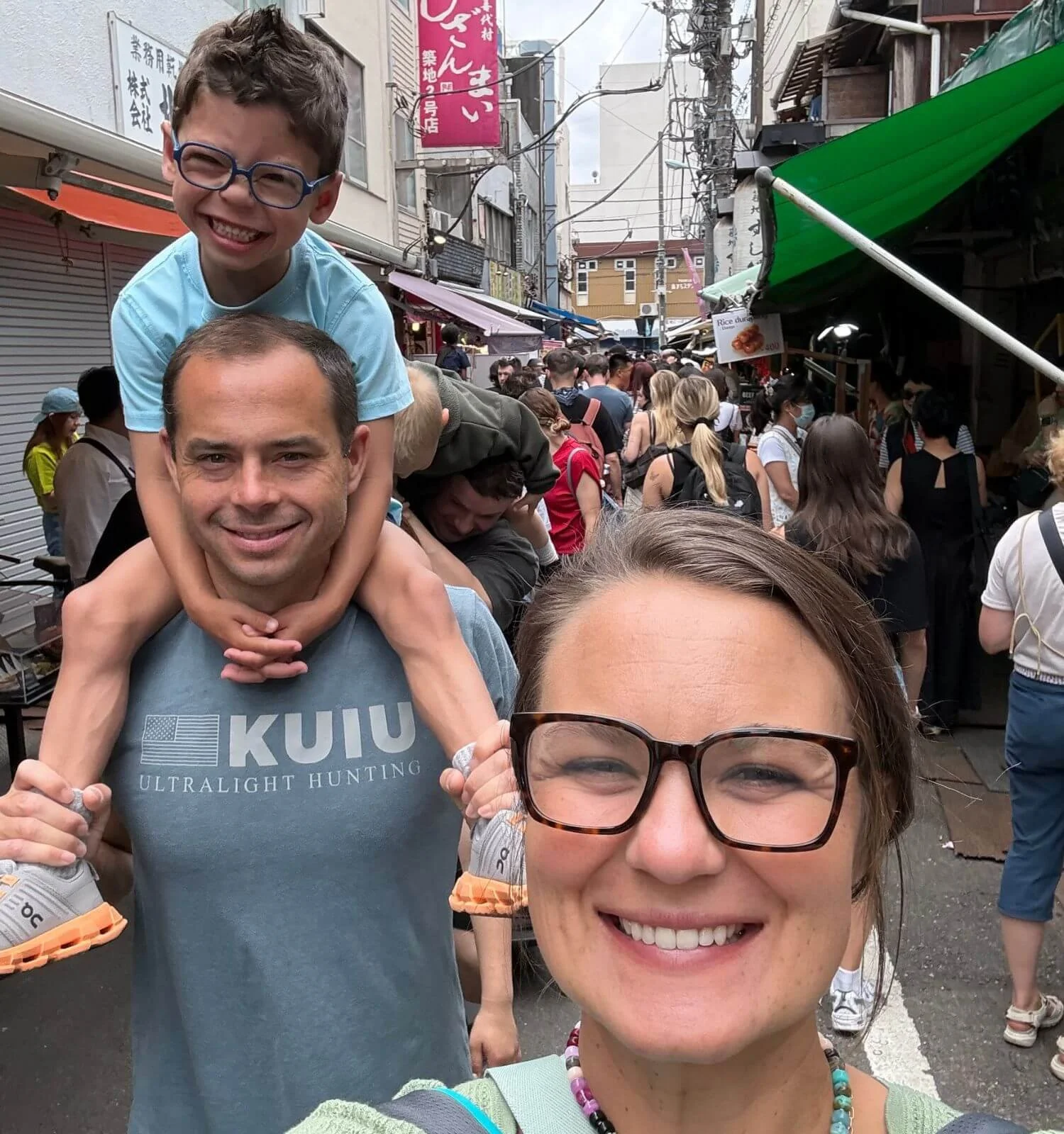 Father carrying his son on his shoulders while walking through Tsukiji Outer Market in Tokyo, Japan
