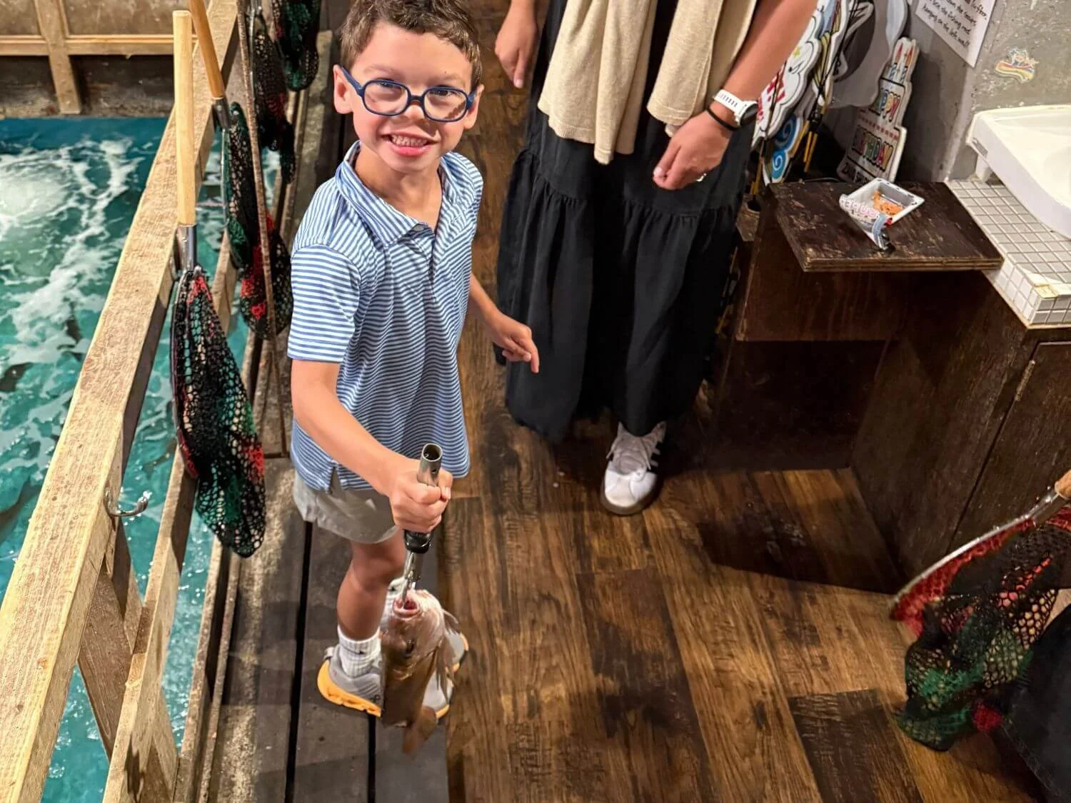 Boy holding fish he caught at Zauo Fishing Restaurant in Tokyo Japan