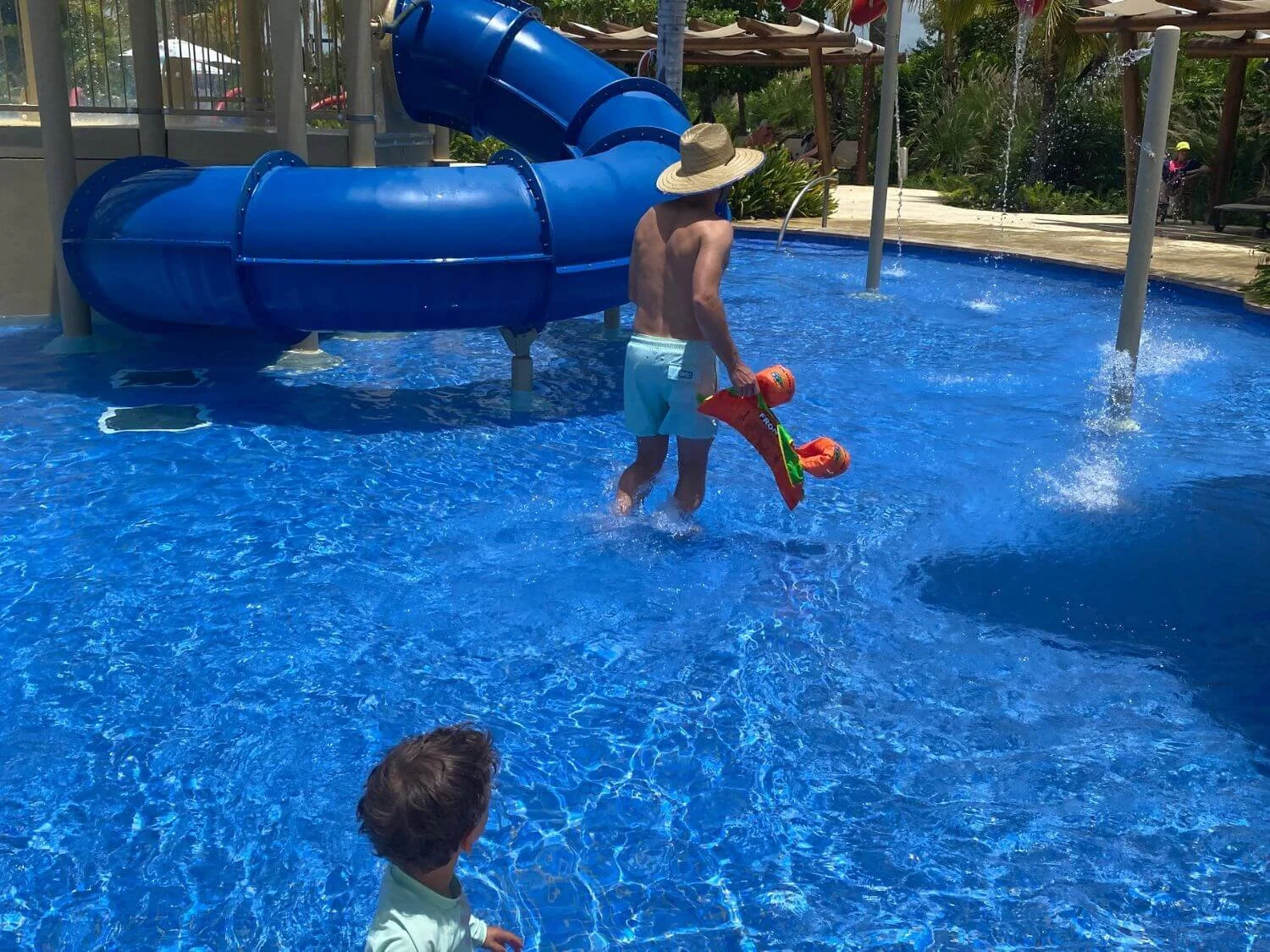 Father and son in the water park spash area at Hyatt Ziva Cap Cana in the Dominican Republic.