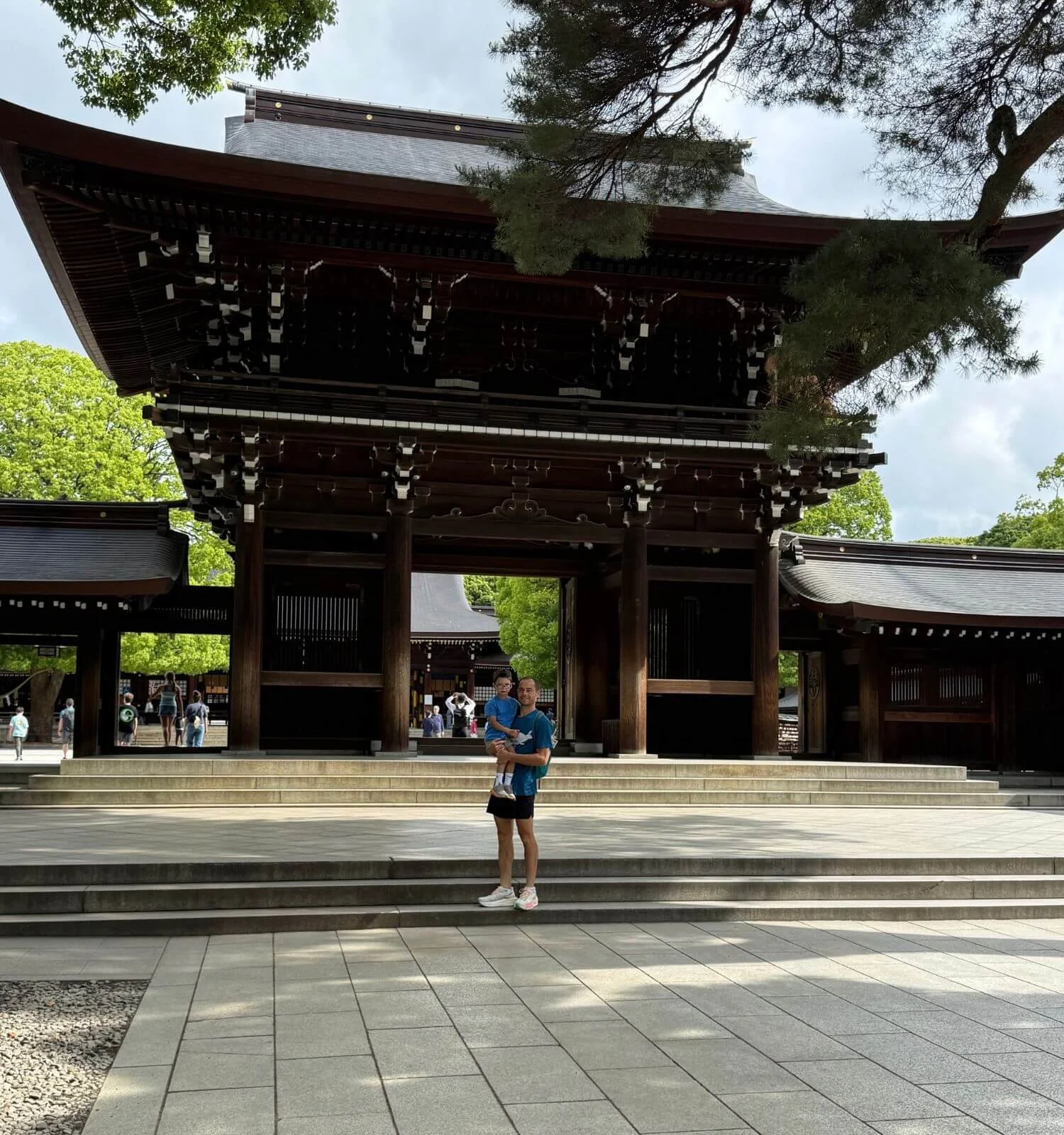 Father and son standing in front of the entrance gate at Meiji Shrine in Tokyo, Japan