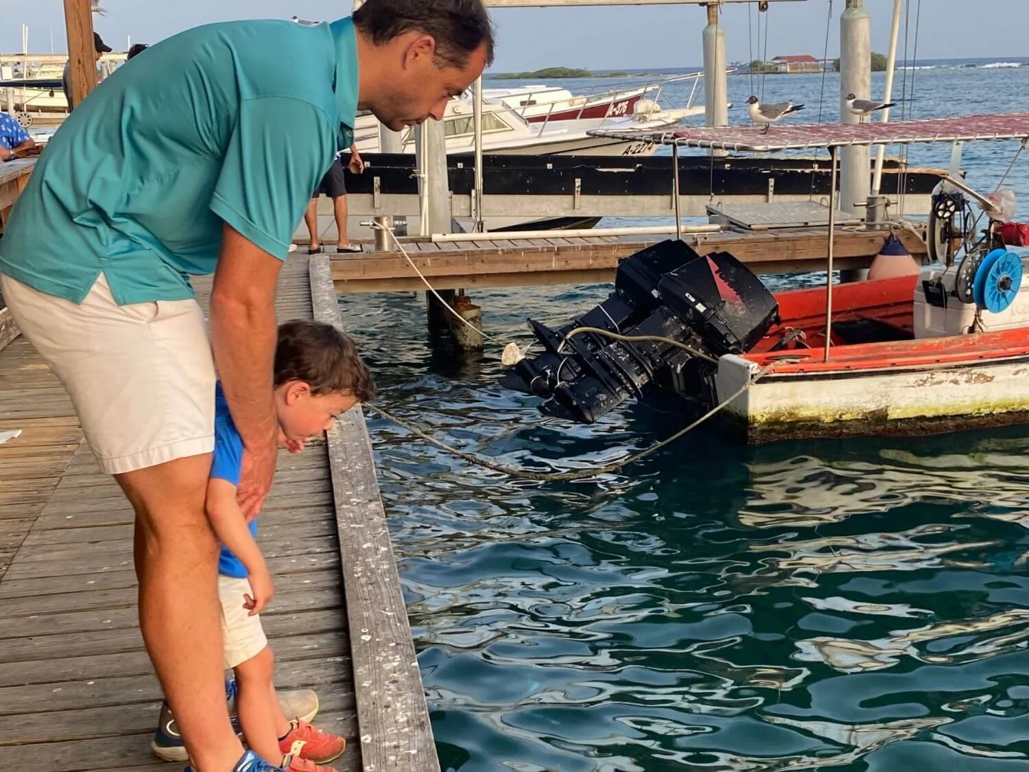 Father and son watching the tarpon off the dock at Zeerovers in Aruba.