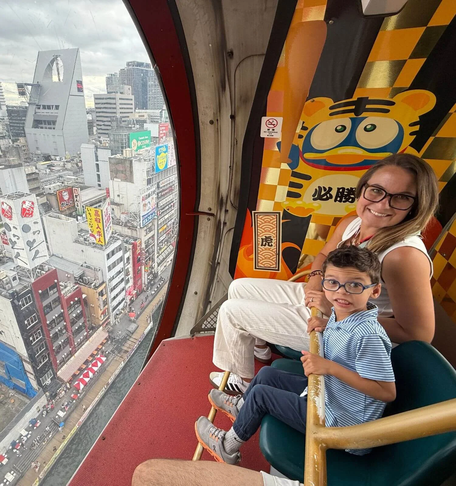 Mom and son inside the ferris wheel at Don Quijote store on Dotonbori street in Osaka Japn.