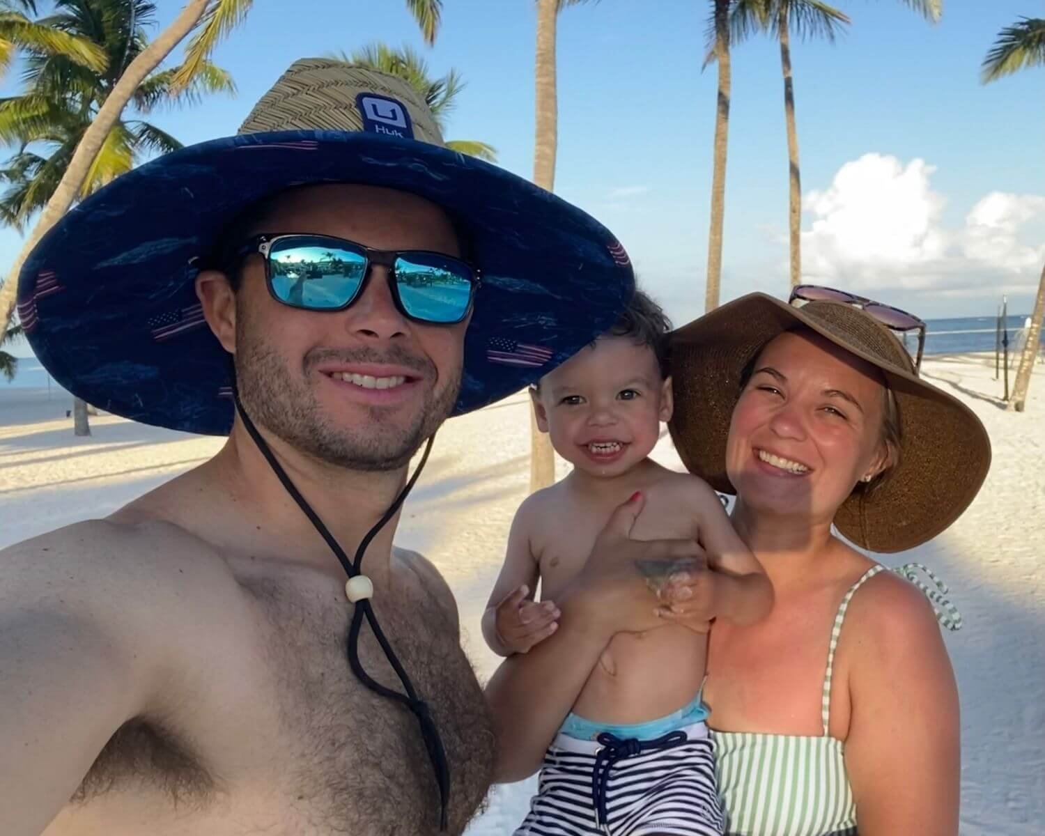 Family on the beach with palm trees and ocean views in the Dominican Republic -  explore our Caribbean travel guides
