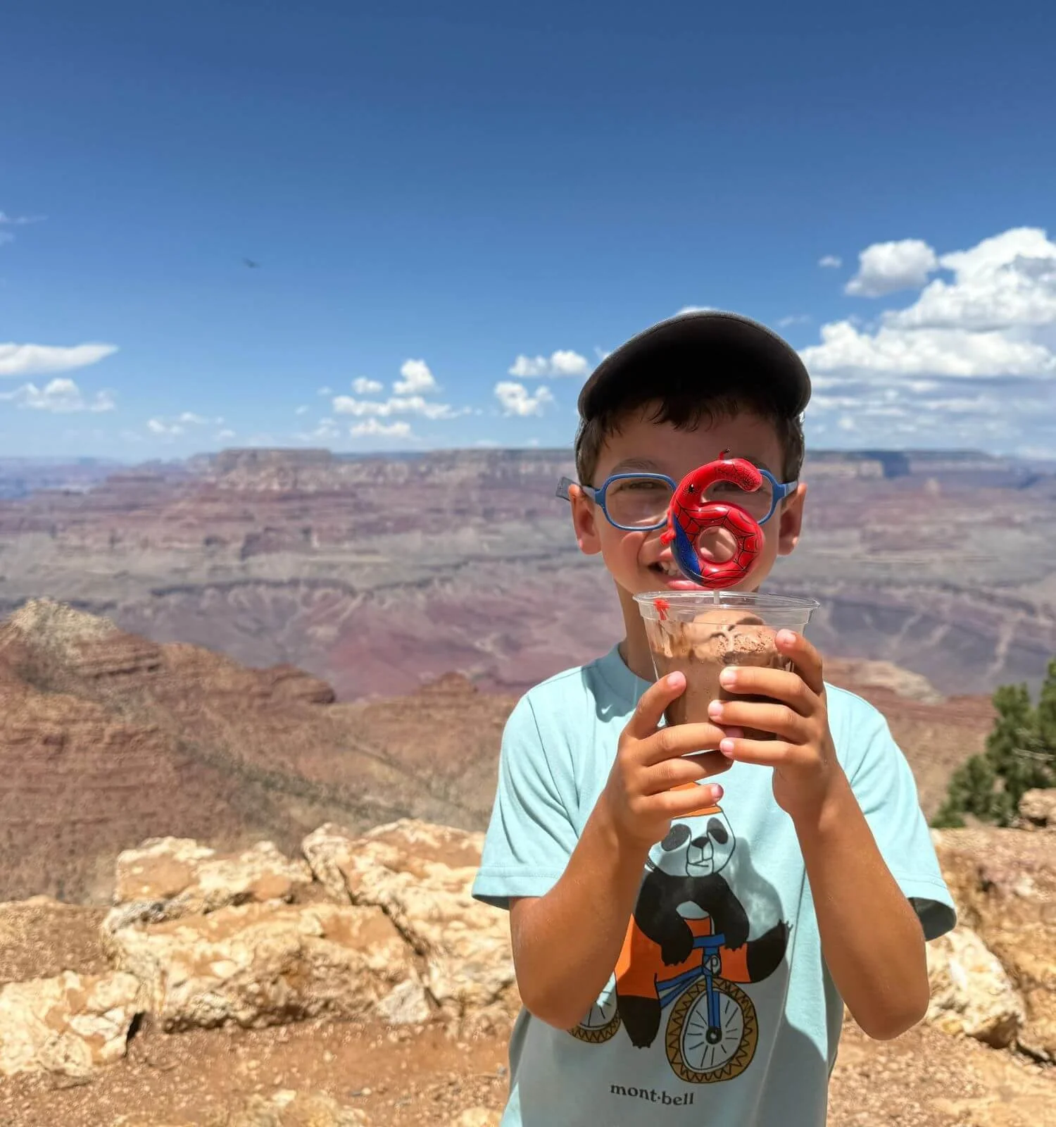 Boy holding ice cream with a birthday candle at desert view overlook in the Grand Canyon National Park.