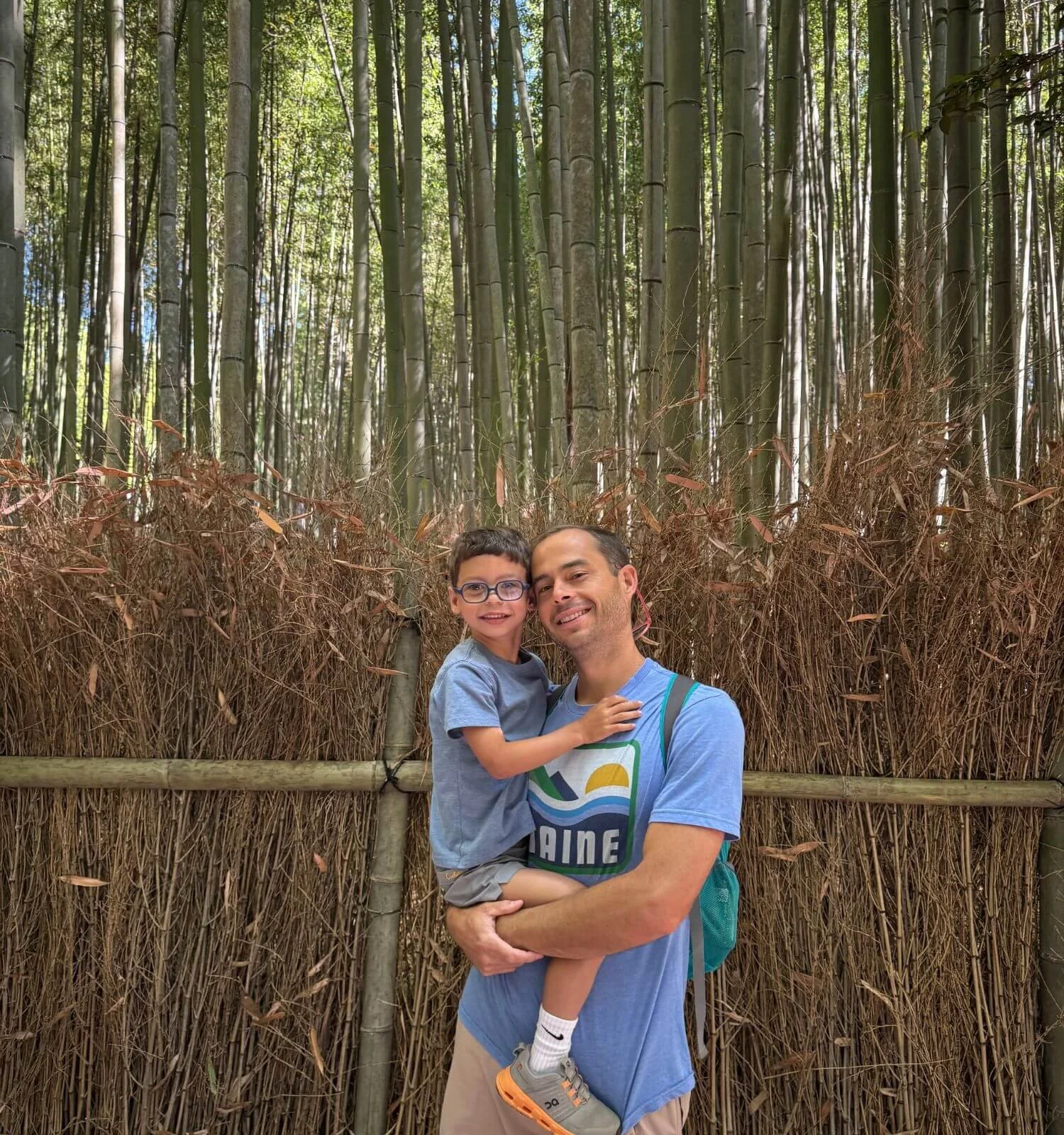 A father and son standing together in the bamboo grove in Kyoto, Japan.