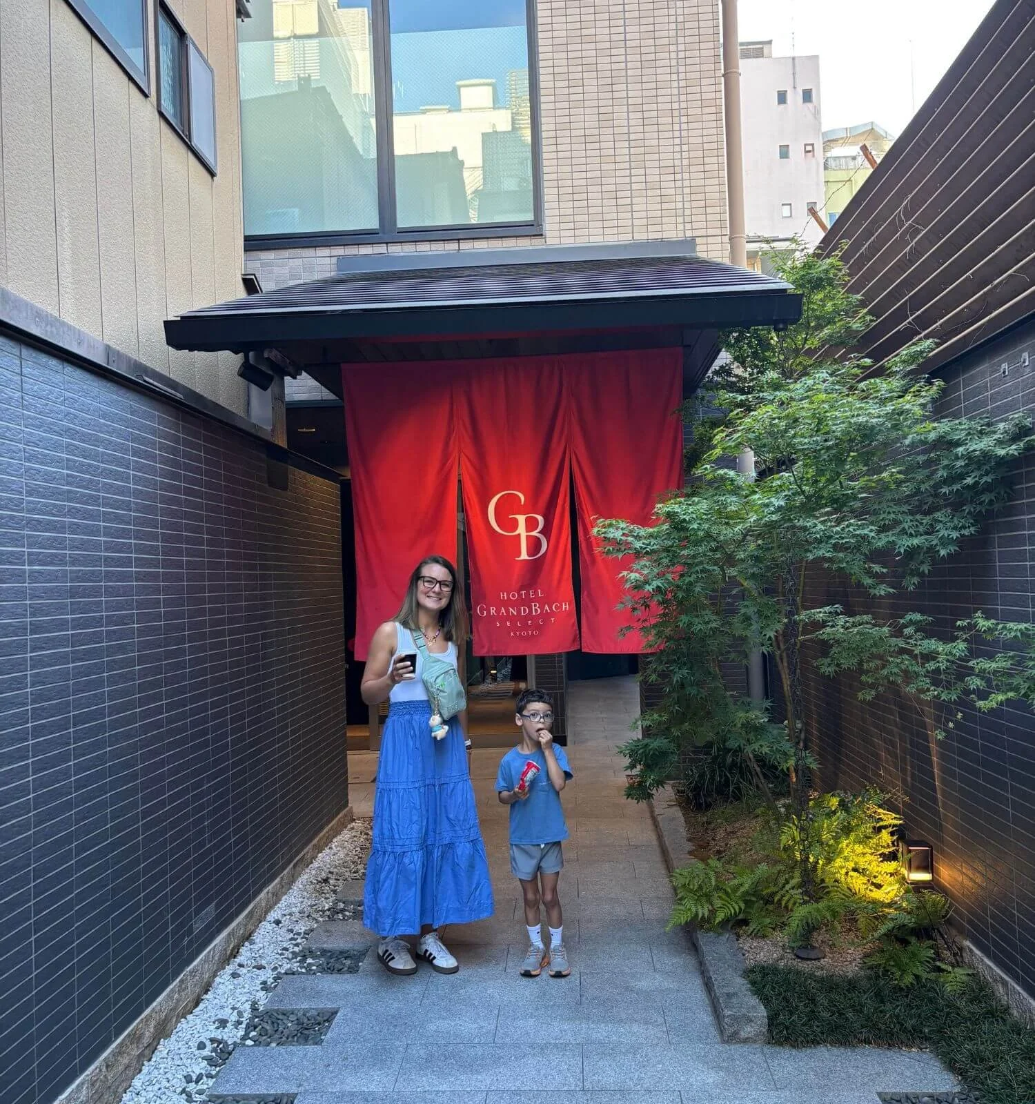 Parent and son standing outside Hotel Grand Bach Kyoto Select in Kyoto, Japan