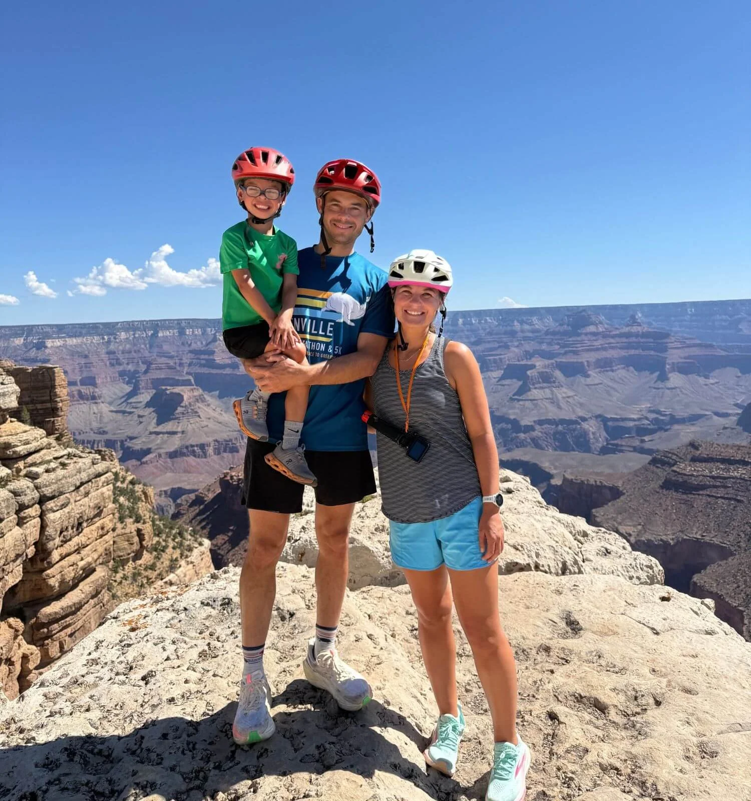 Family of 3 smiling at a scenic overlook along Hermit's Road in the Grand Canyon National Park in Arizona, United States